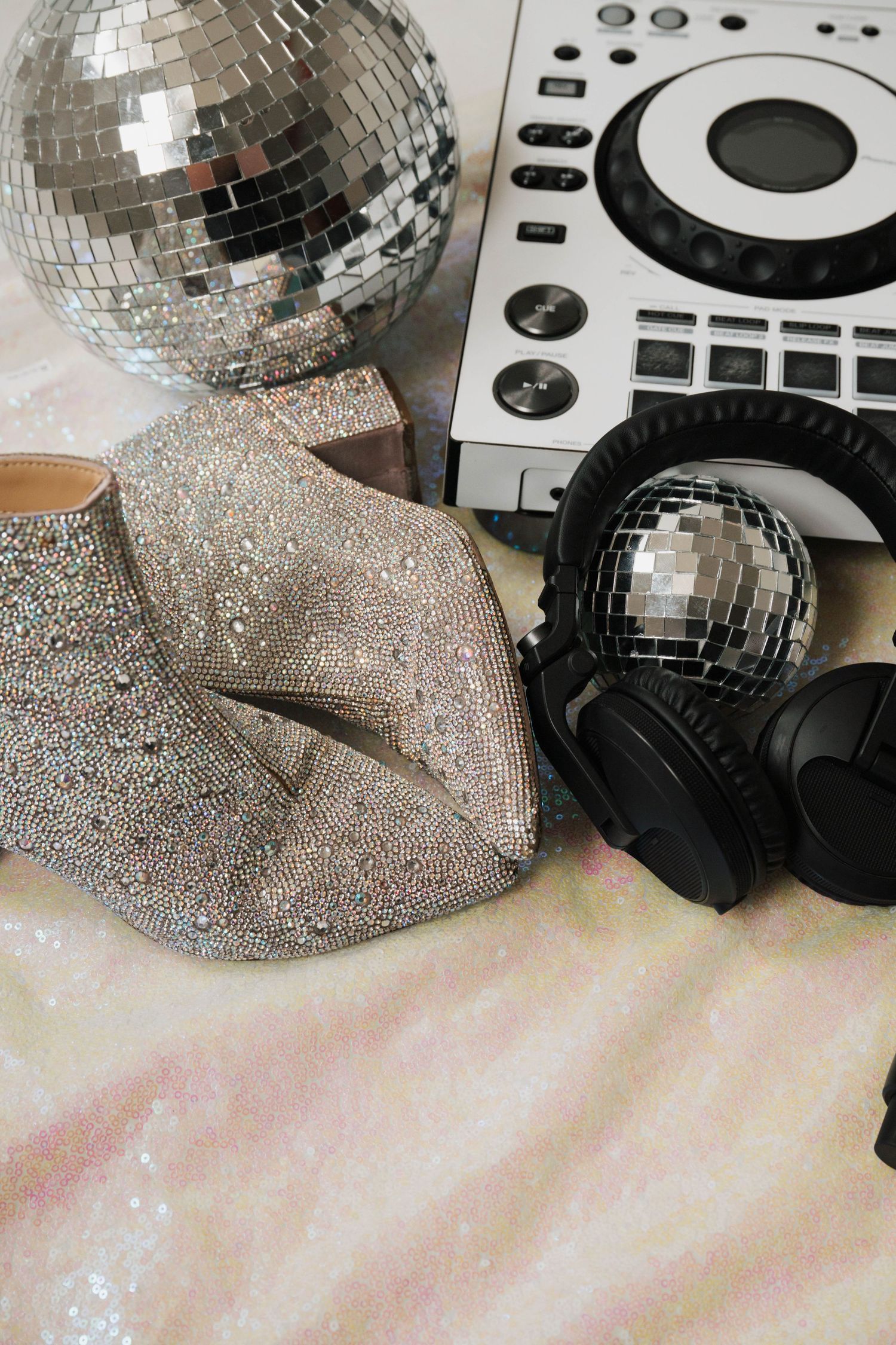 Shiny disco ball and DJ equipment with silver glitter details.