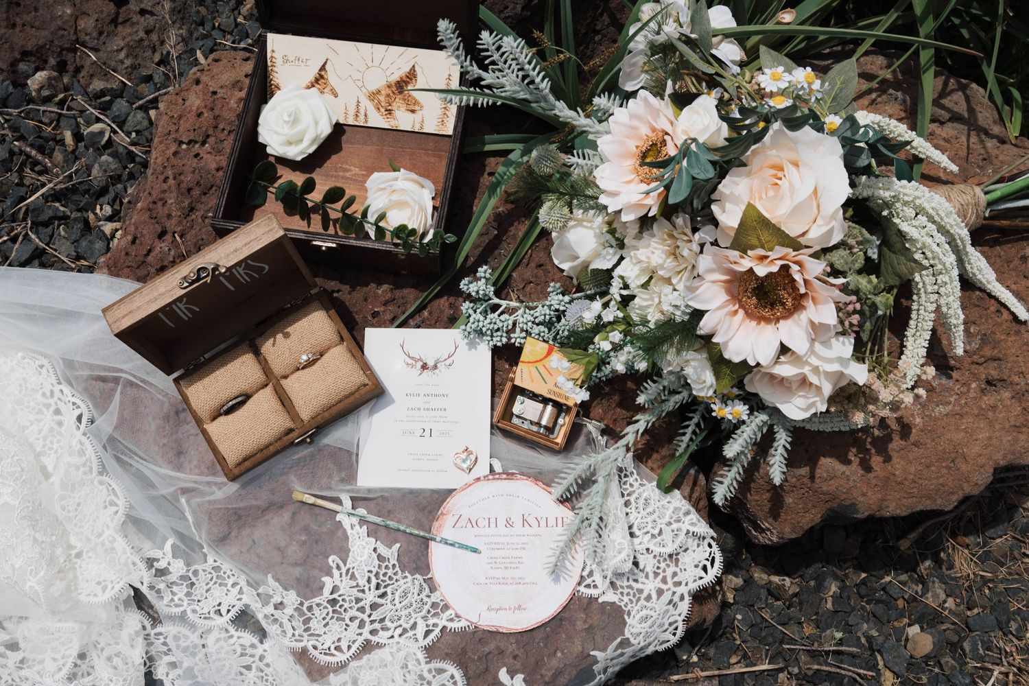 Rustic wedding details with vintage lace, flowers, and handwritten notes arranged on wooden surface.