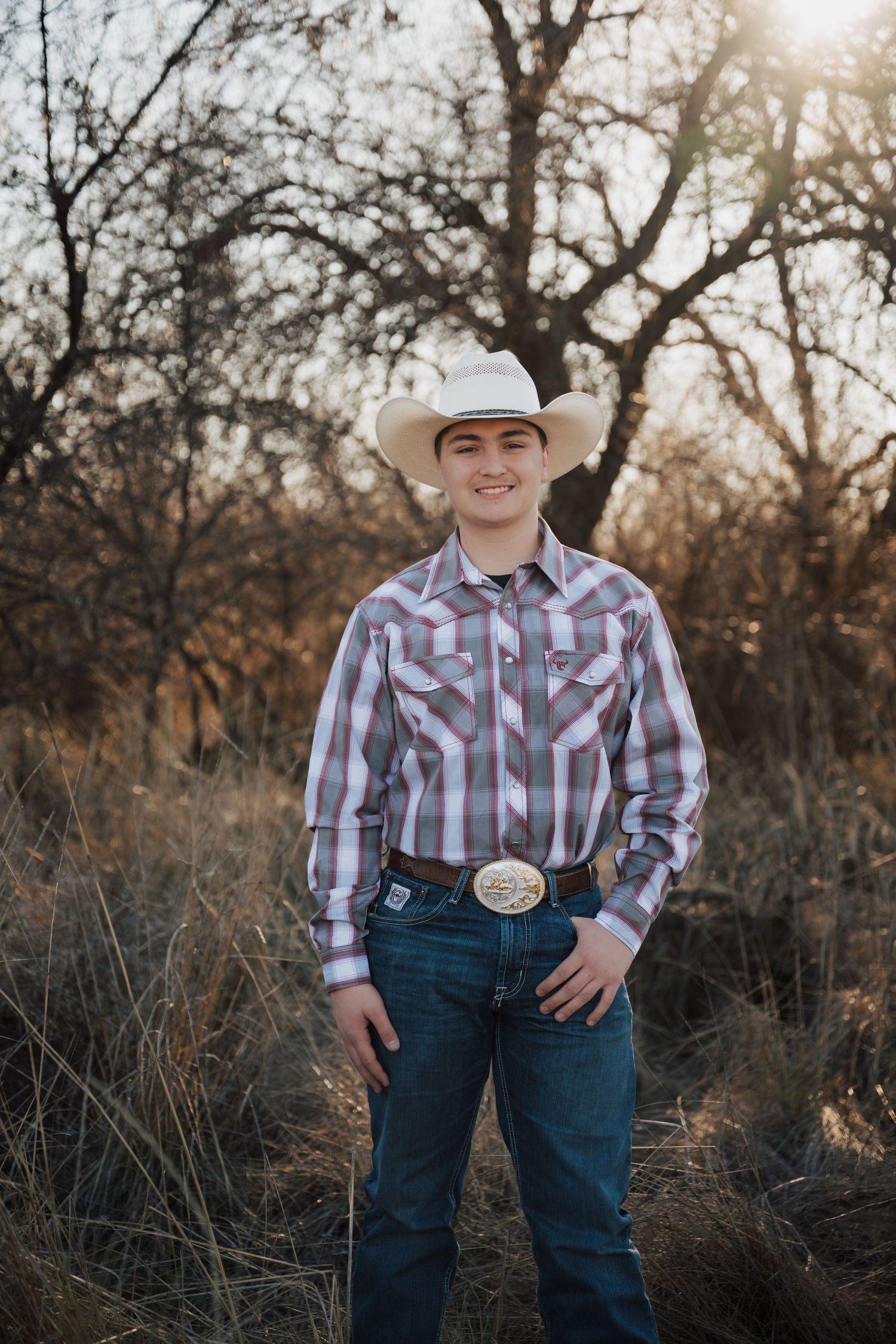 A western-styled photoshoot featuring plaid shirt and cowboy hat in a rustic outdoor setting.