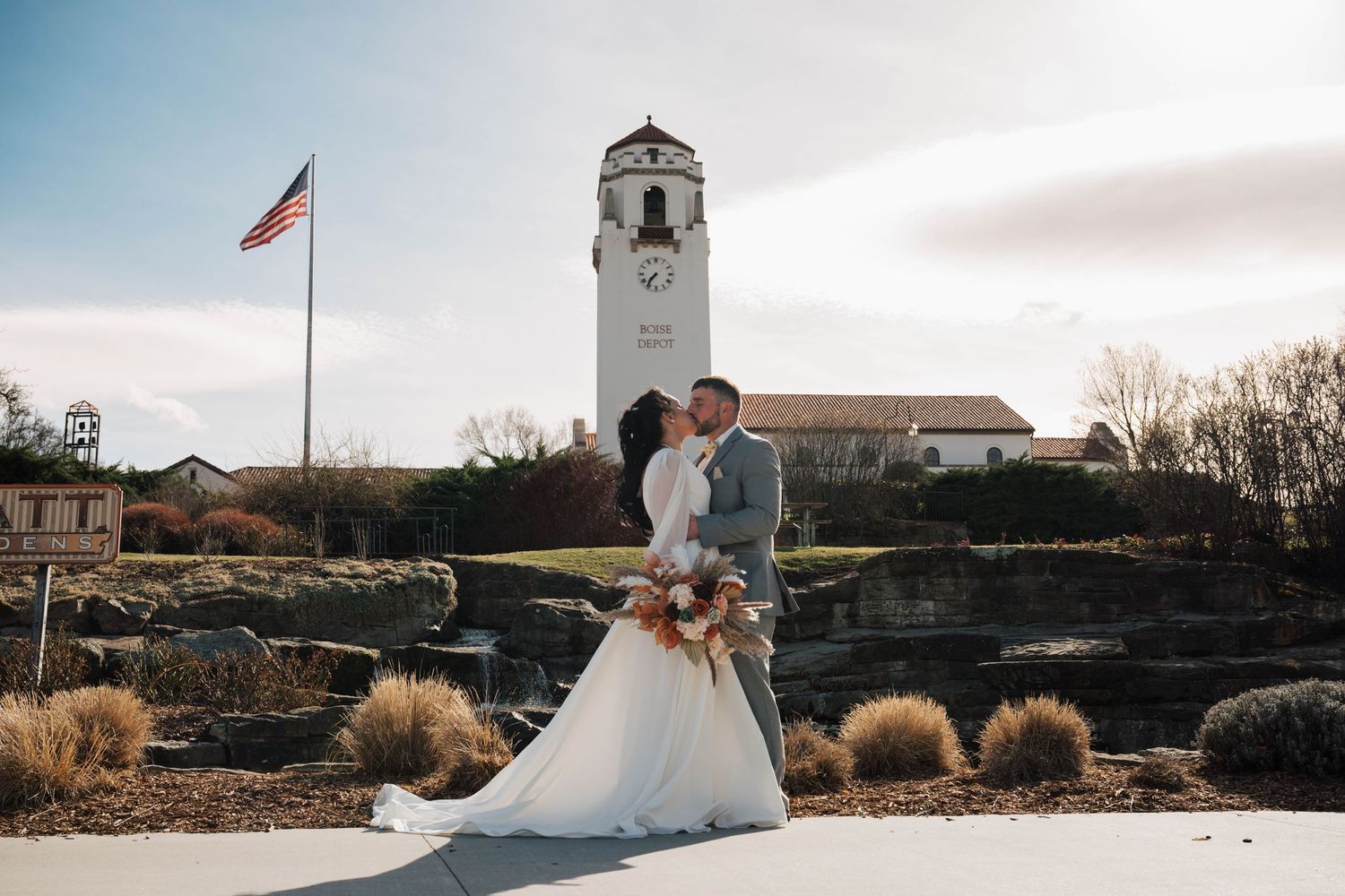 Panoramic wedding venue view with chapel bell tower and American flag against cloudy sky.
