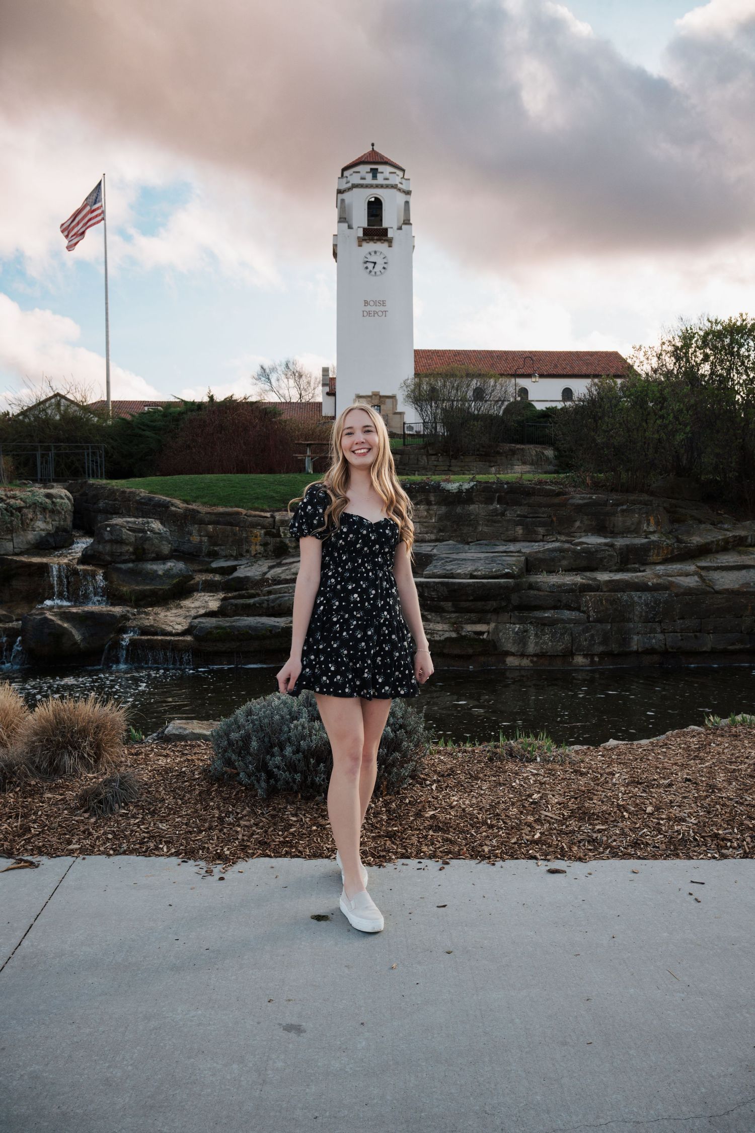 Scenic lighthouse photo shoot with rocky coastline and American flag.