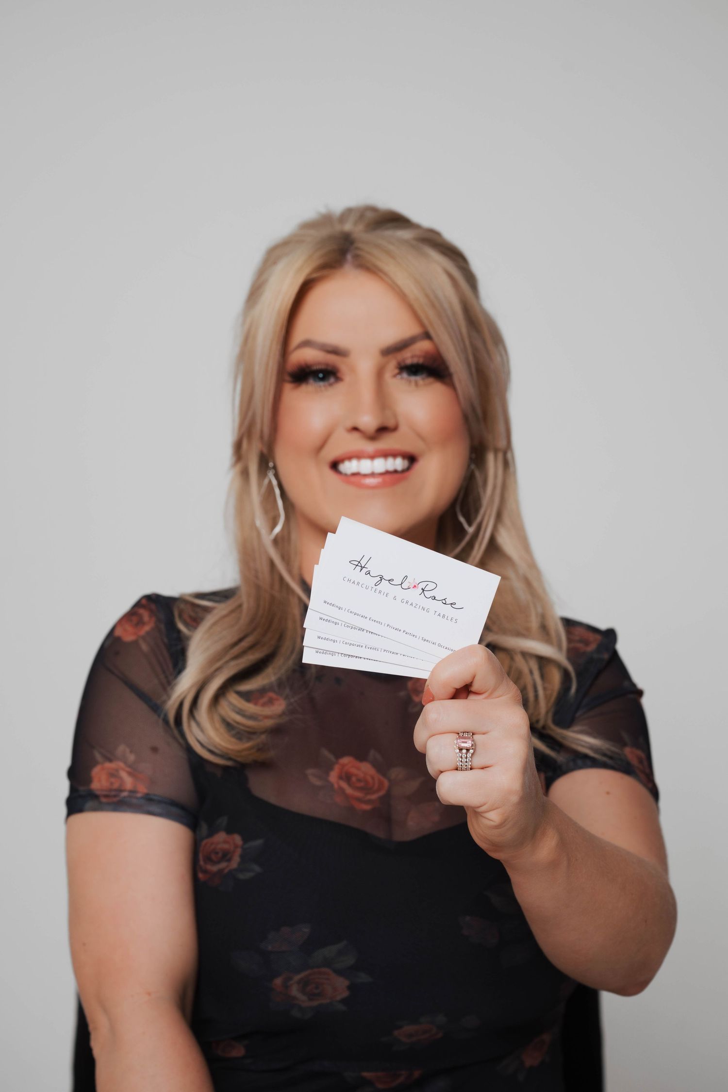 Business cards being displayed against grey studio background.