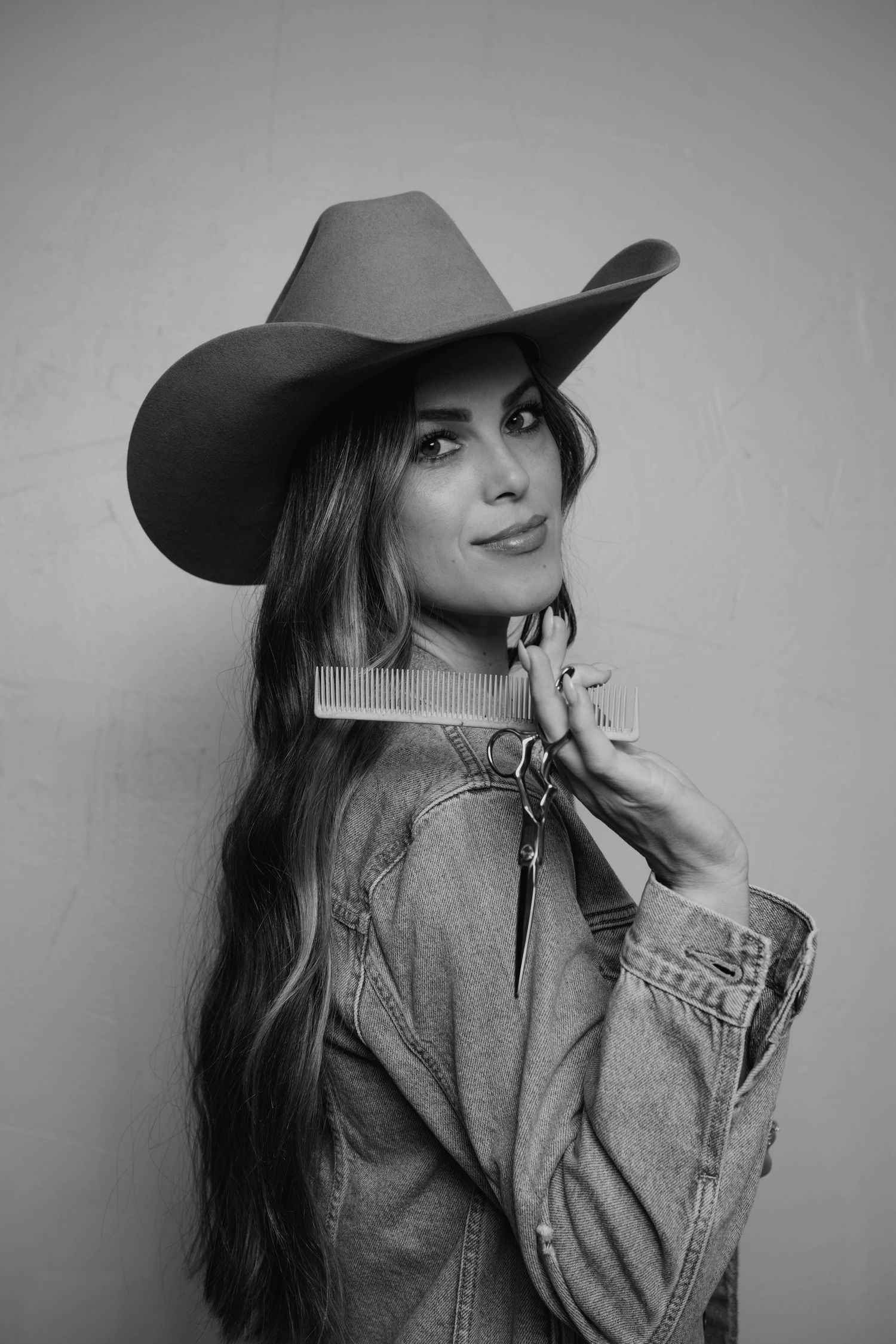Black and white fashion portrait with a cowboy hat and denim styling.