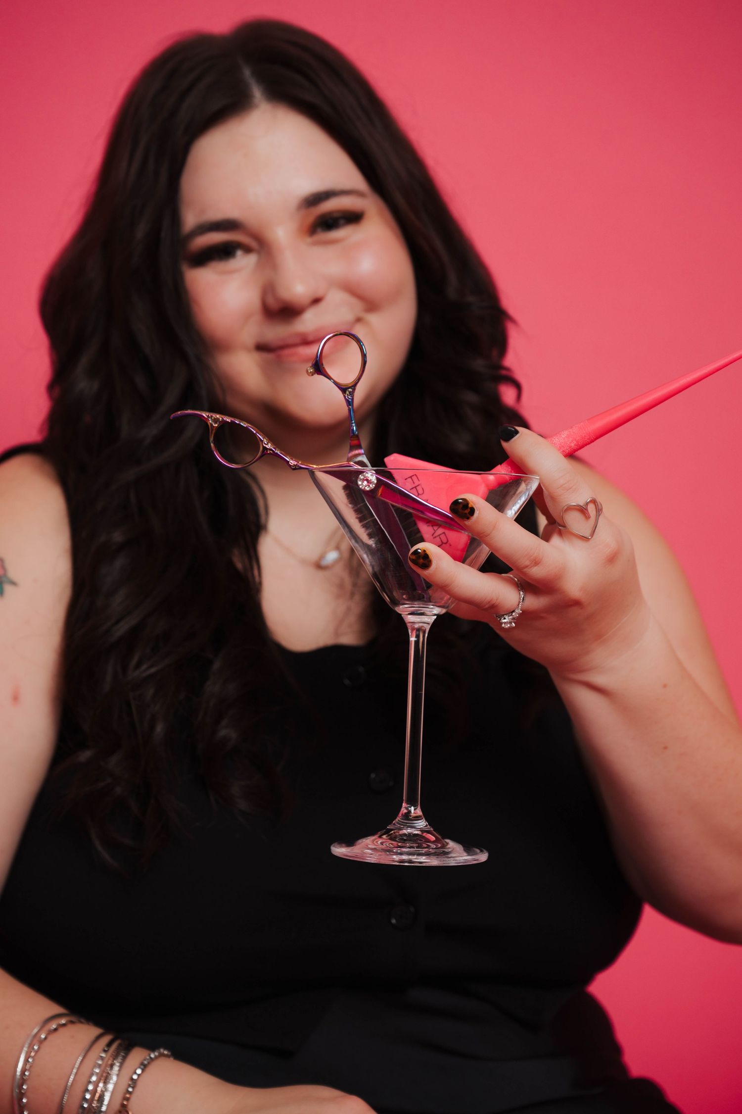 Person enjoying cocktails and drinks against a pink backdrop.