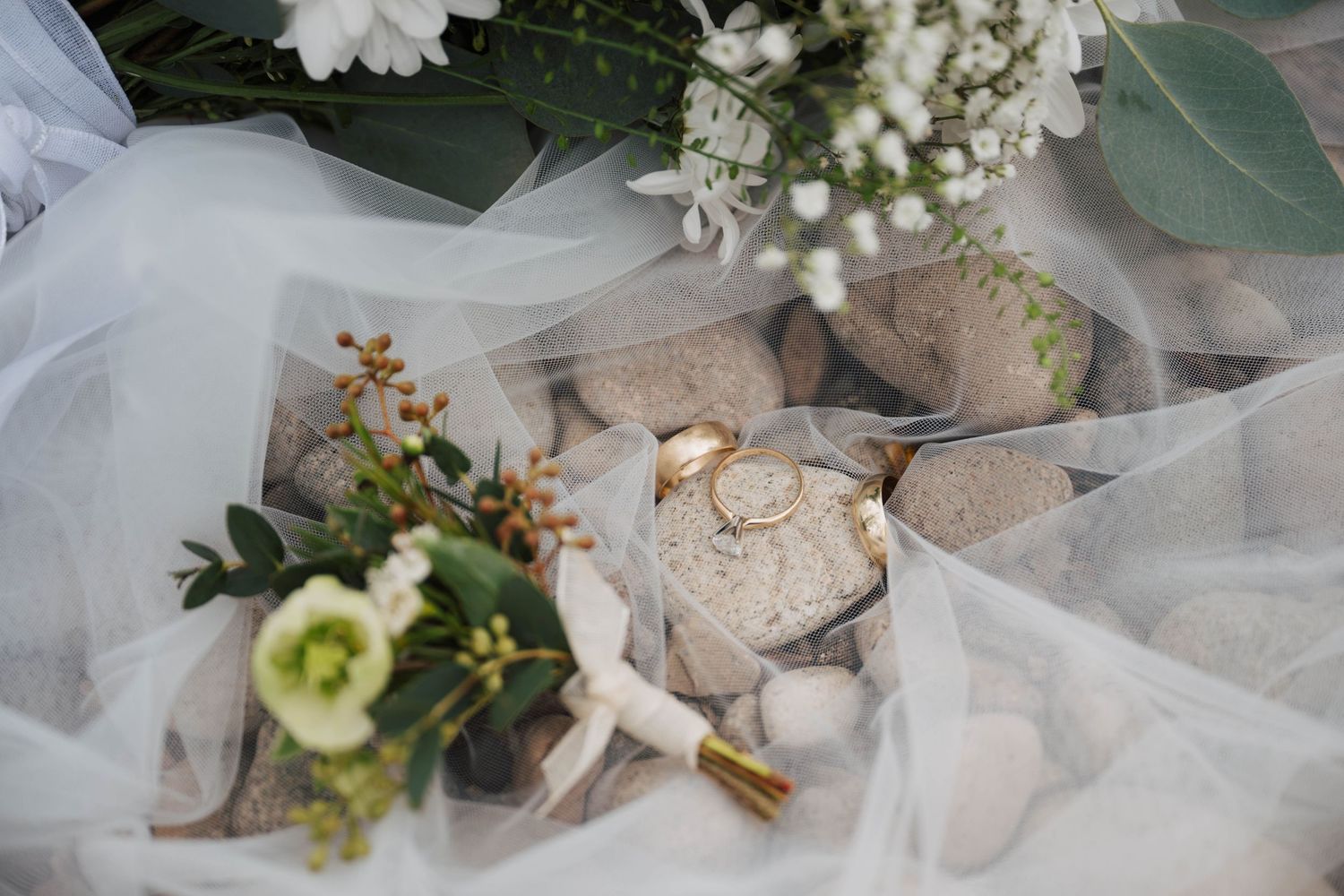 Elegant wedding details featuring white tulle veil and delicate floral arrangements.