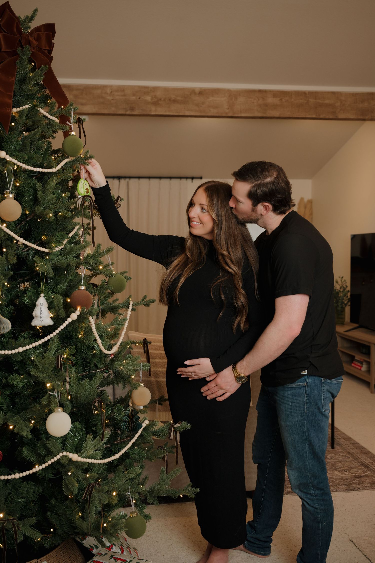 Couple decorating Christmas tree together in cozy home setting.