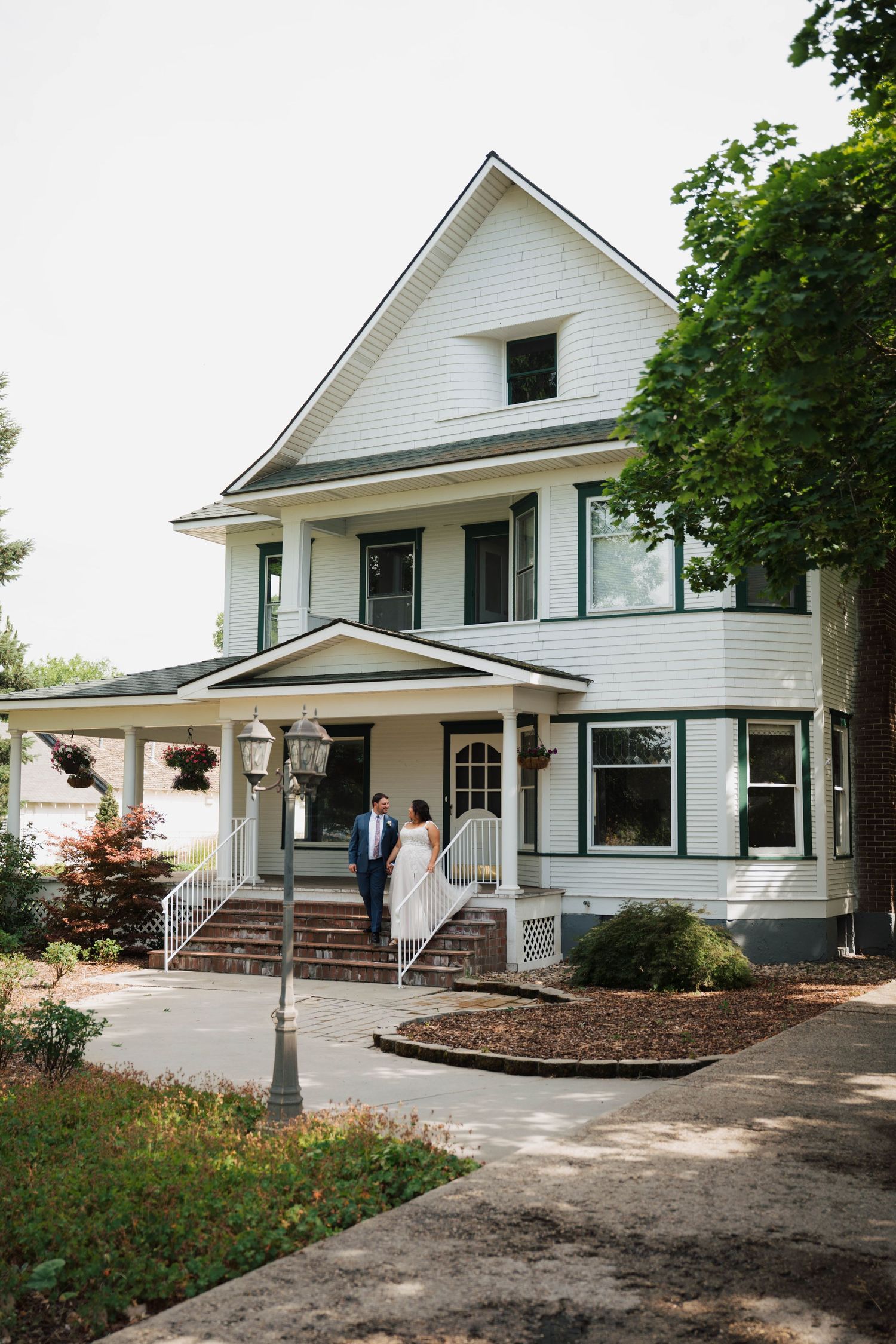 Bride and groom outside the historic house at Fourth Street Gardens wedding venue in Emmett, Idaho