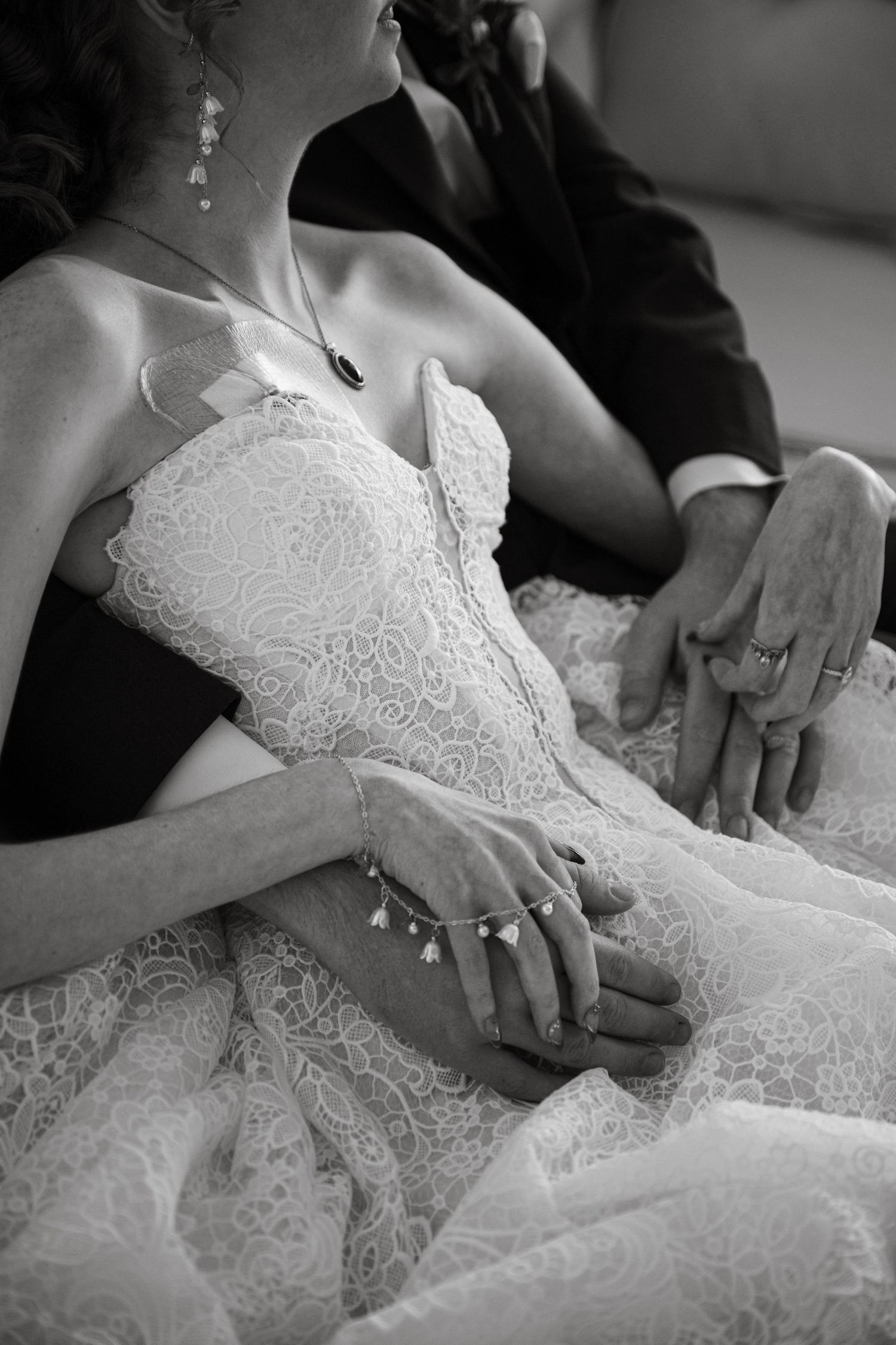 Close-up wedding detail photo of the bride's dress as she embraces the groom at Mint Barrel Barn in Nampa, Idaho.