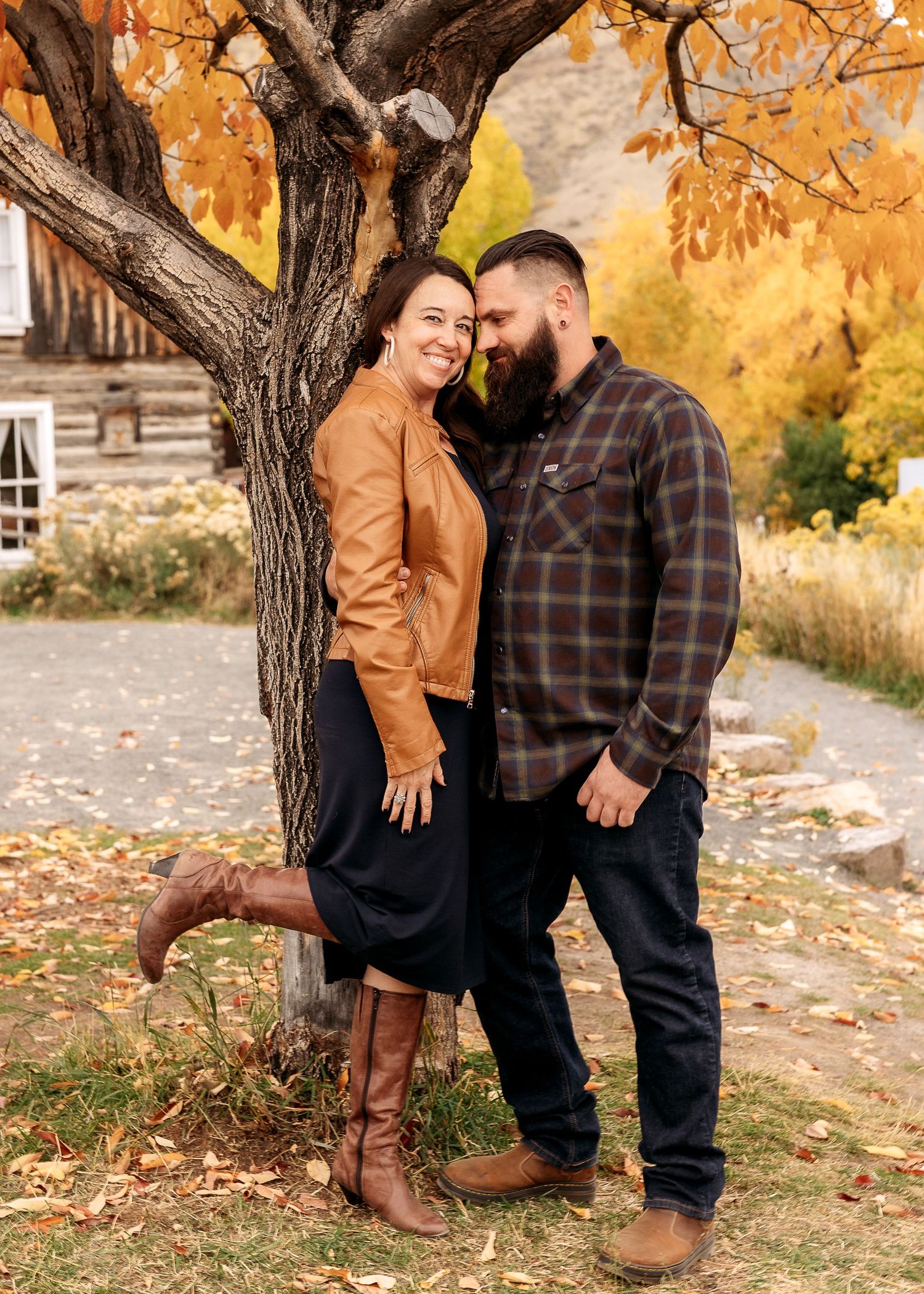 Couple photography posing playfully against autumn trees in Golden, Colorado during a natural light lifestyle session.