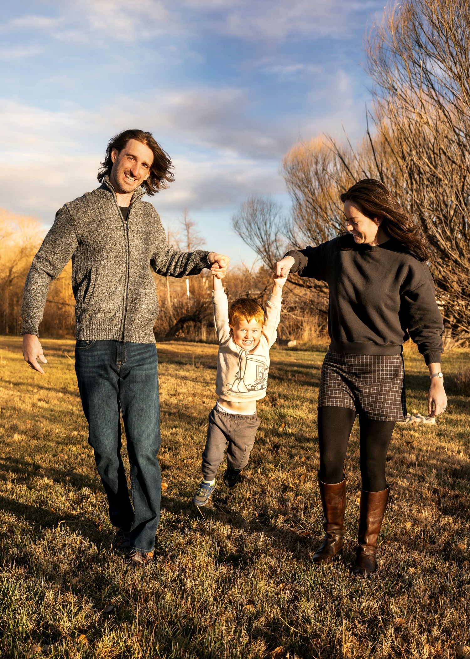 A candid family portrait session with a toddler in winter capturing golden colors and fun family poses in Arvada, Colorado.