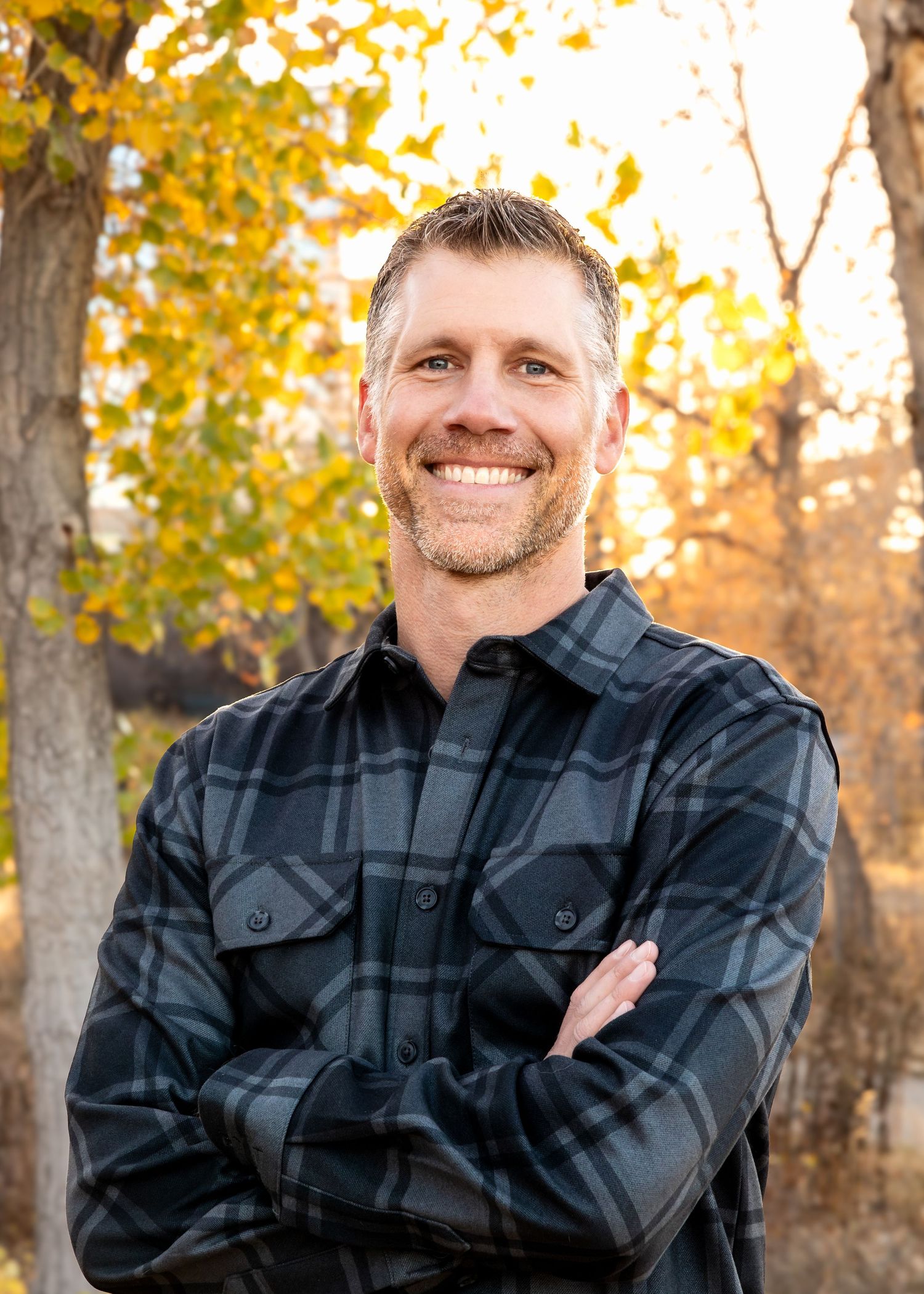 Professional headshot in Denver Co of sales executive for website, email, and online profiles in plaid shirt taken with mobile studio.