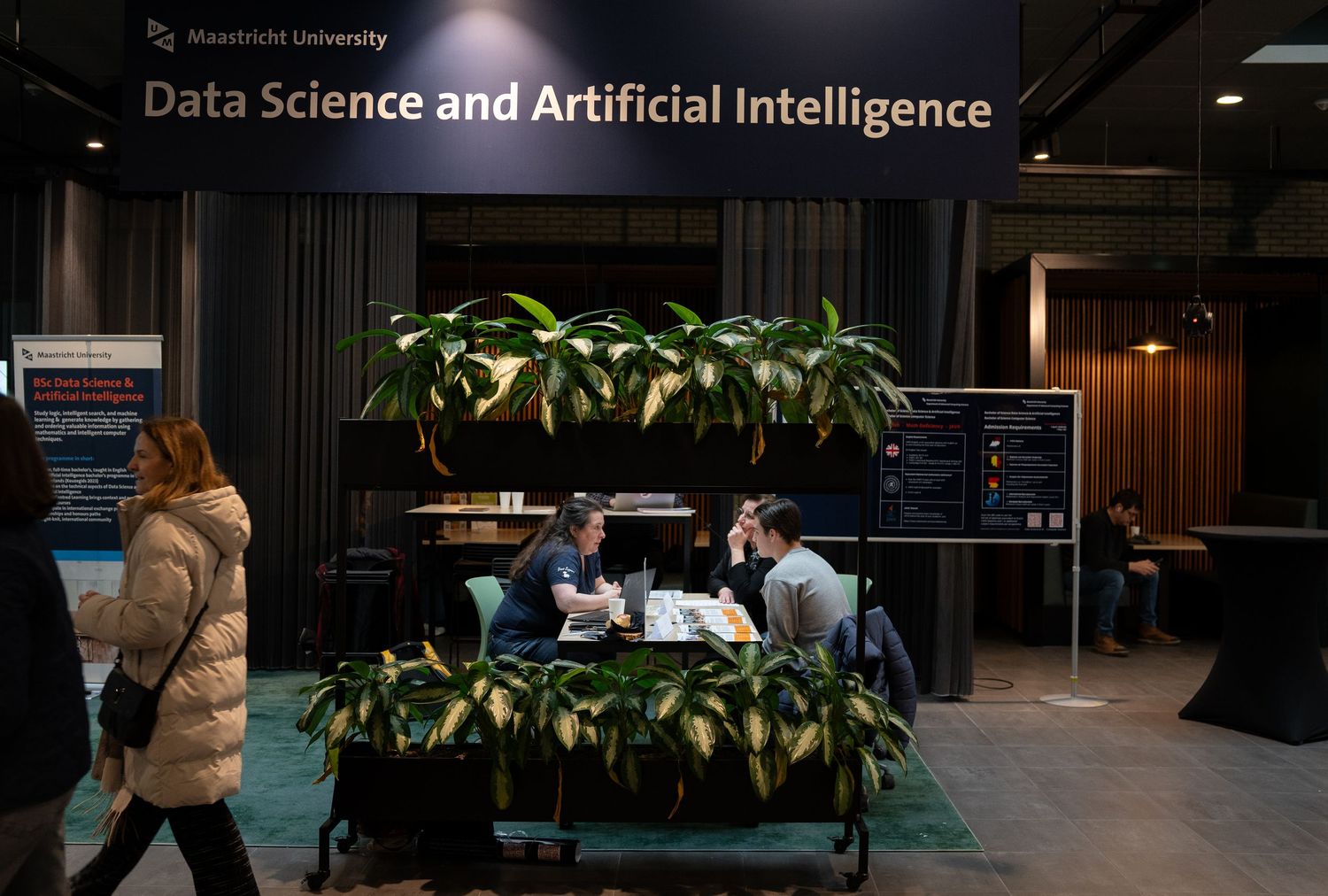 Visitors explore Maastricht University Data Science and Artificial Intelligence booth at an education fair.