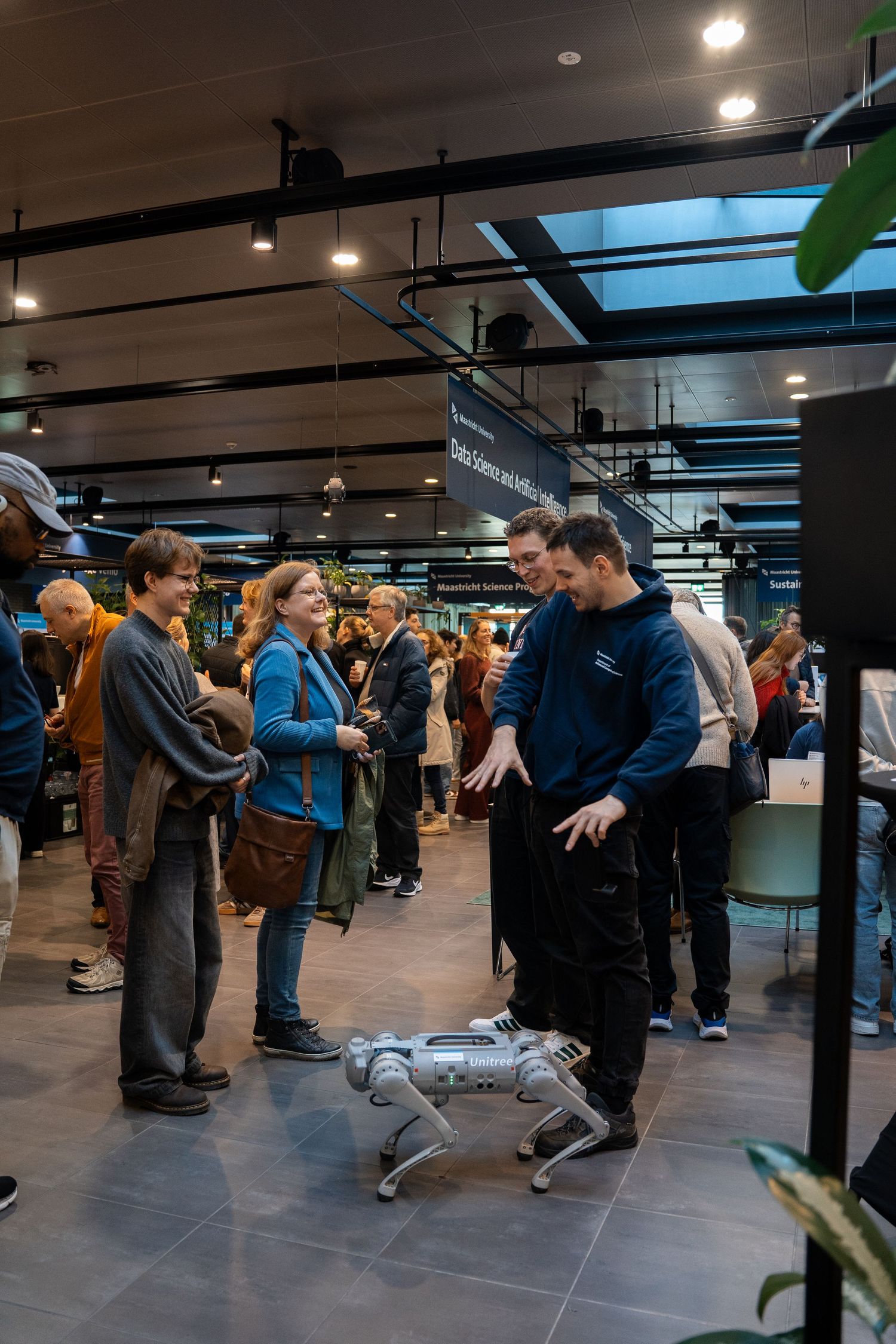 Students demonstrate a robotic dog to curious visitors at Maastricht University Data Science open day.