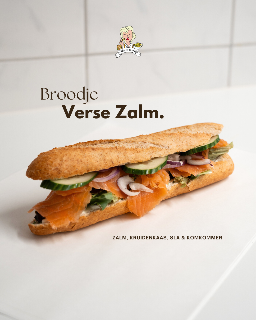 Fresh salmon sandwich on a baguette with cream cheese, lettuce, cucumber, and red onion on a white surface.