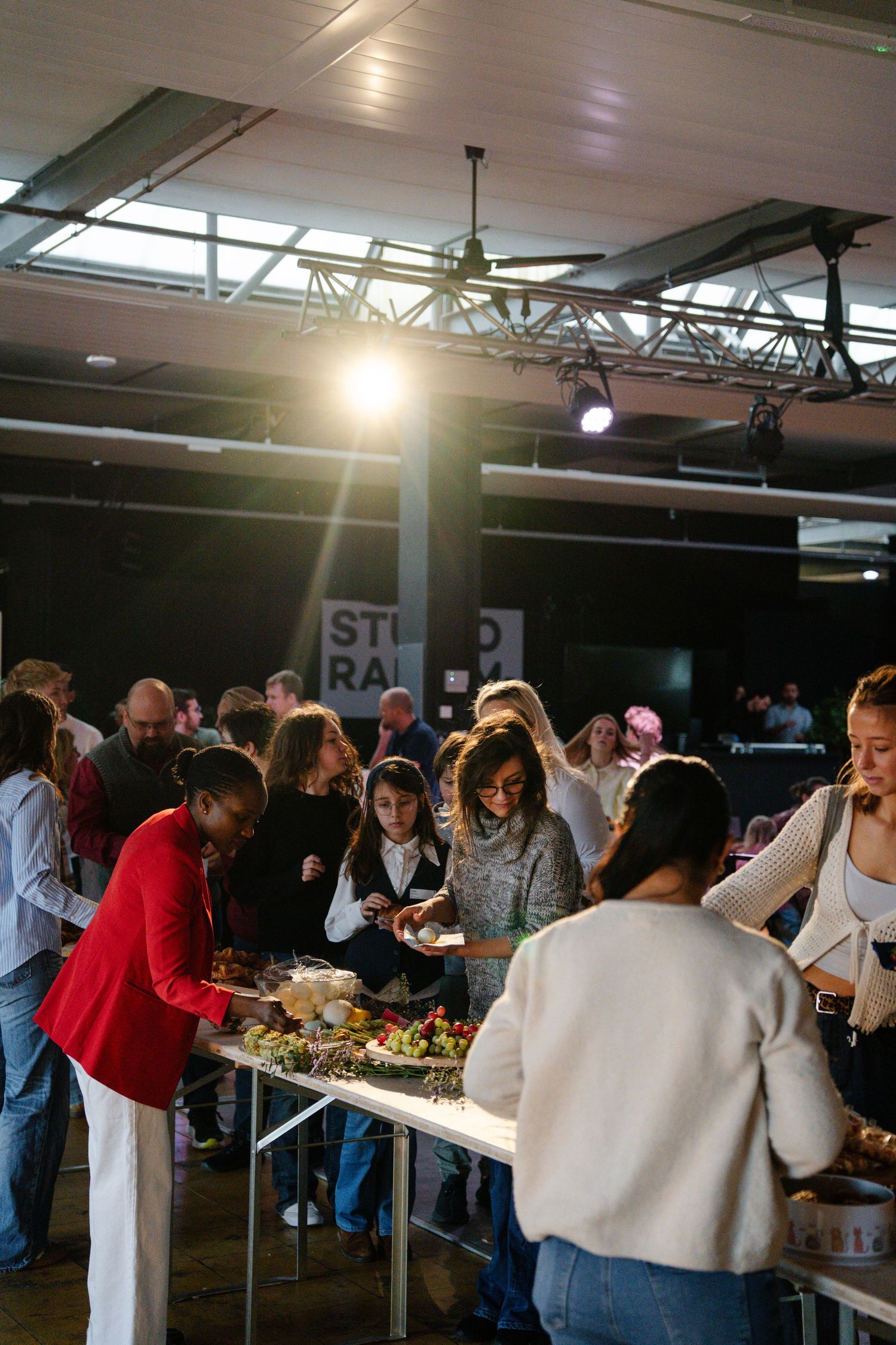 Diverse group of people gathered around a buffet table with fresh food at a church community event.