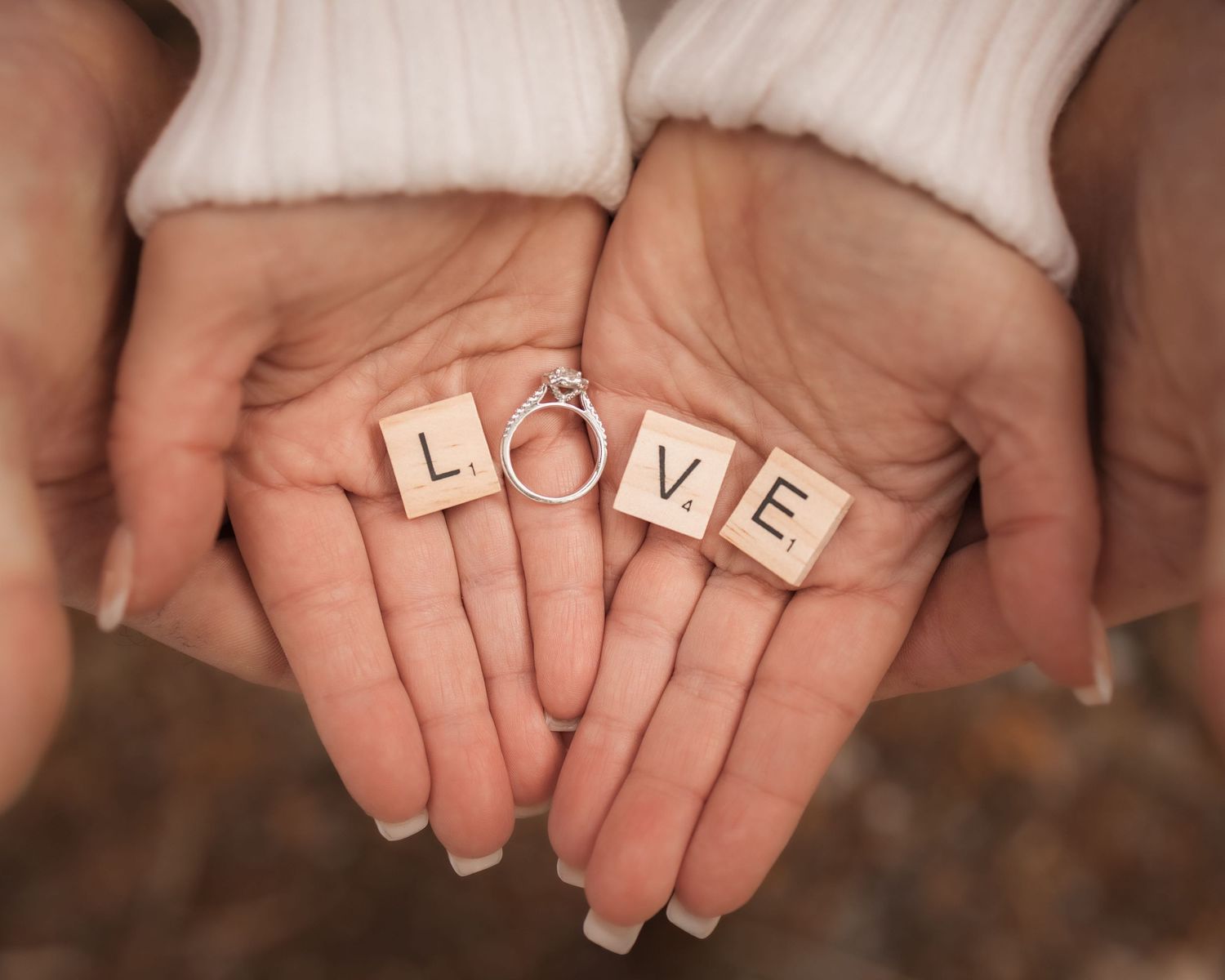 Waukesha engagement photography at Retzer Park. Close-up of woman’s hands with ring and Scrabble letters, a playful, elegant detail shot.