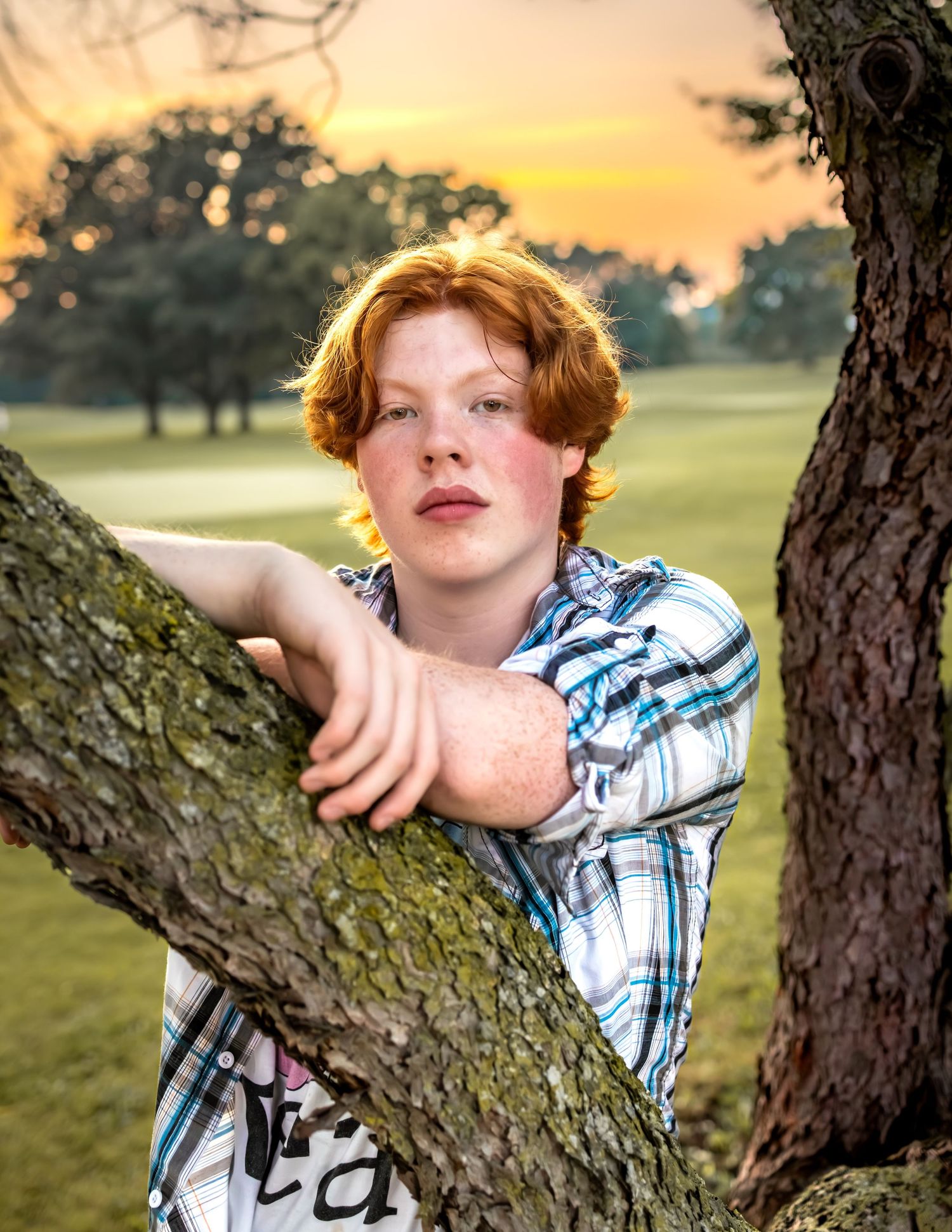 High school senior in Greenfield Park, West Allis, WI. Red-haired teen during golden hour captured in vibrant, cinematic outdoor portrait.