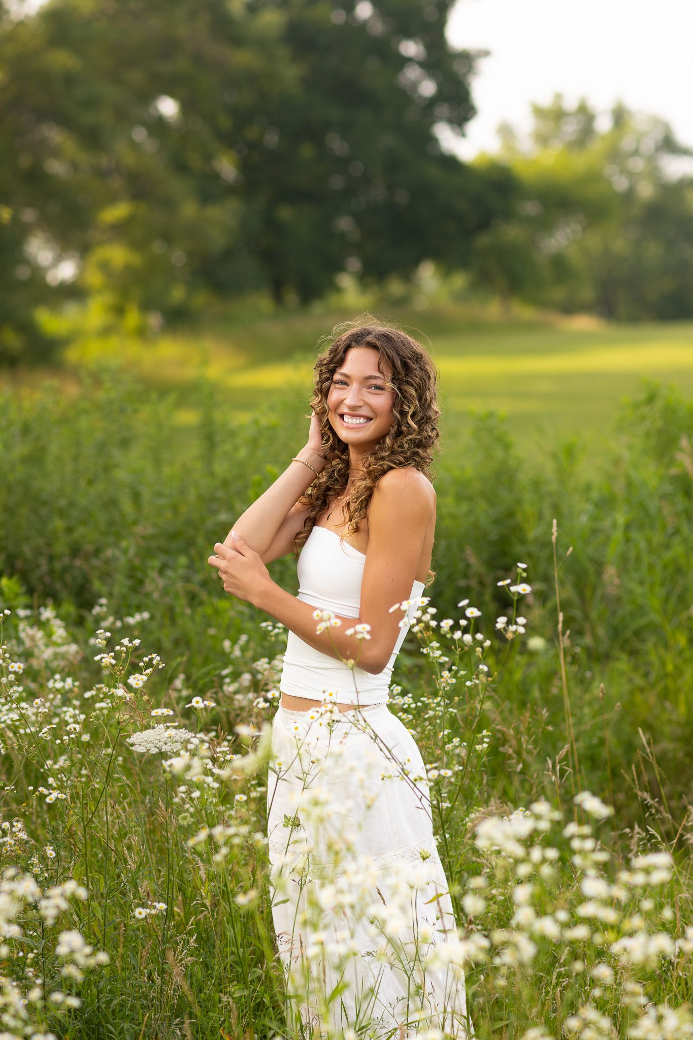 Senior session at Retzer Nature Center, Waukesha. Curly-haired teen, bright eyes, sun streaming through trees in timeless, elegant photos.