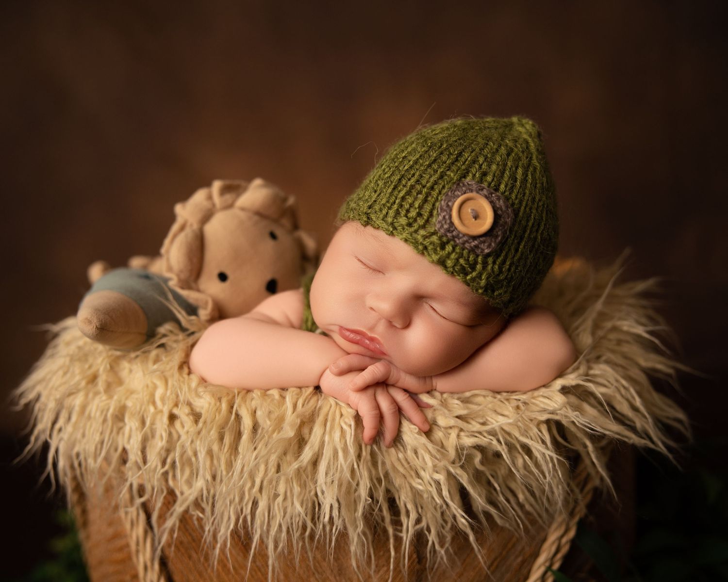 Studio newborn photography, Waukesha. Baby boy wearing green buttoned hat, moody, elegant, and heartwarming portraits at Lake Country Photog