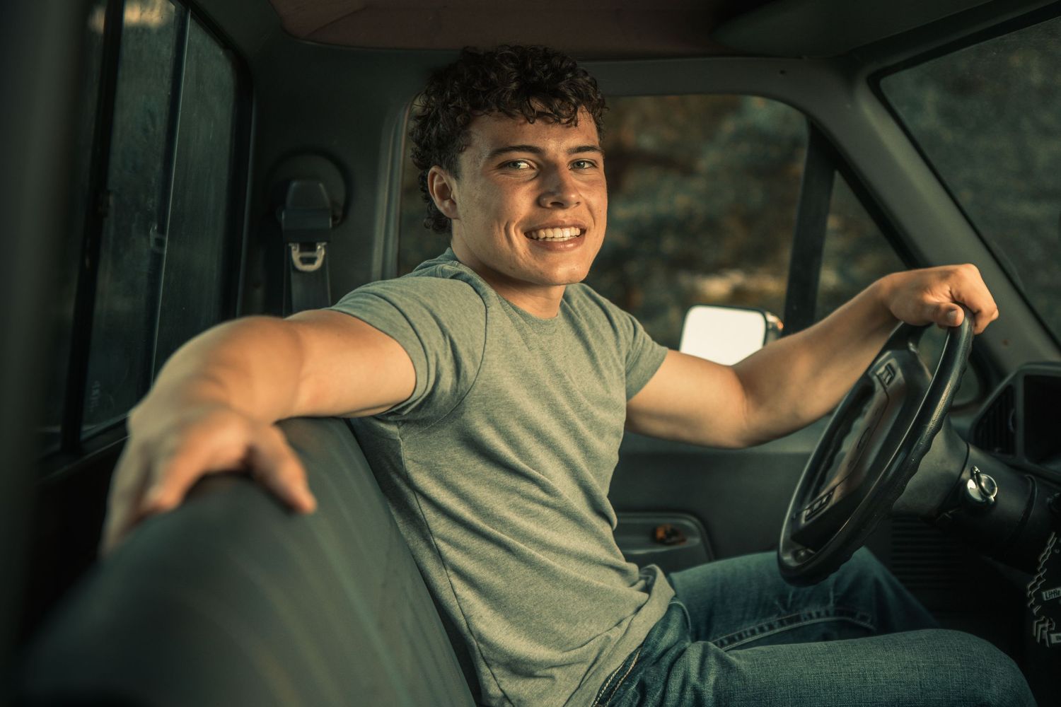 Cinematic high school senior portrait in Oconomowoc. Young man sitting in his vehicle, captured with moody, stylish, editorial vibes.