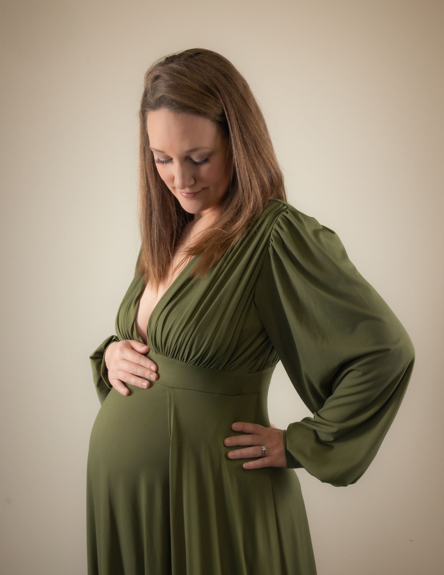 Studio maternity portrait at Lake Country Photography, Waukesha. Tender moment of mom looking down at her baby bump, full of warmth.