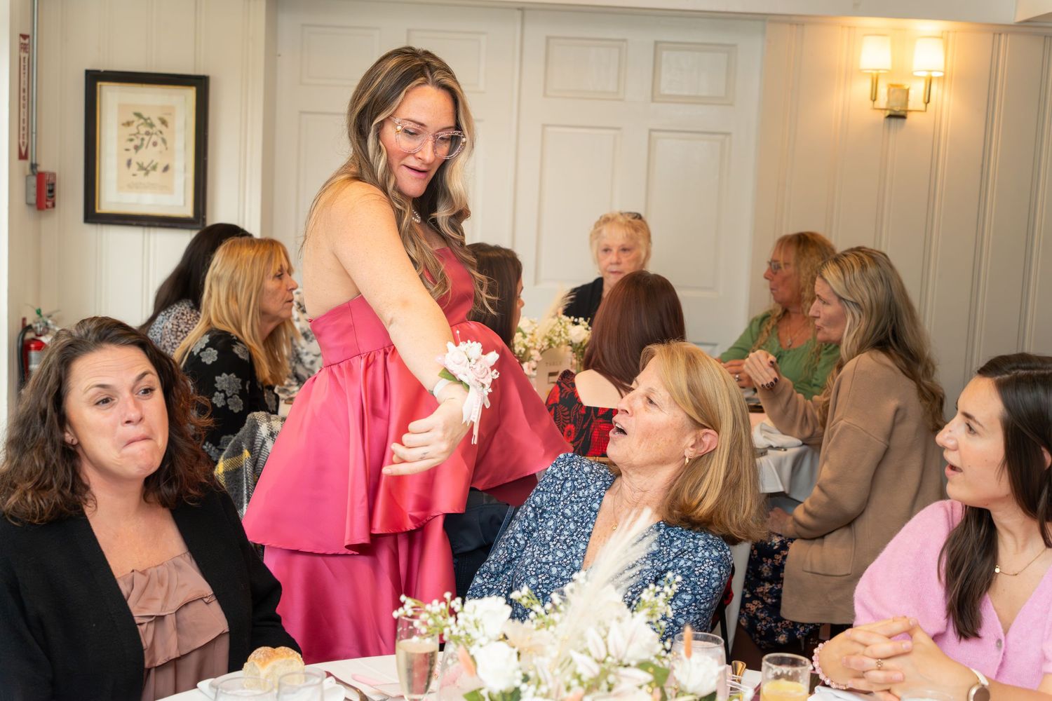 A festive baby shower celebration with guests gathered around decorated tables sharing special moments.