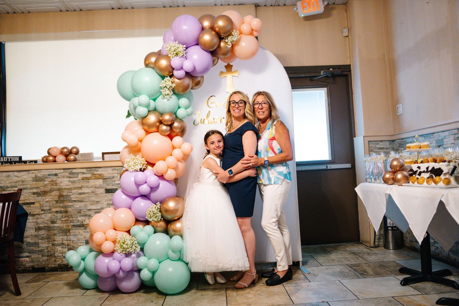 A celebration scene with elegant balloon arch featuring pastel and gold balloons.