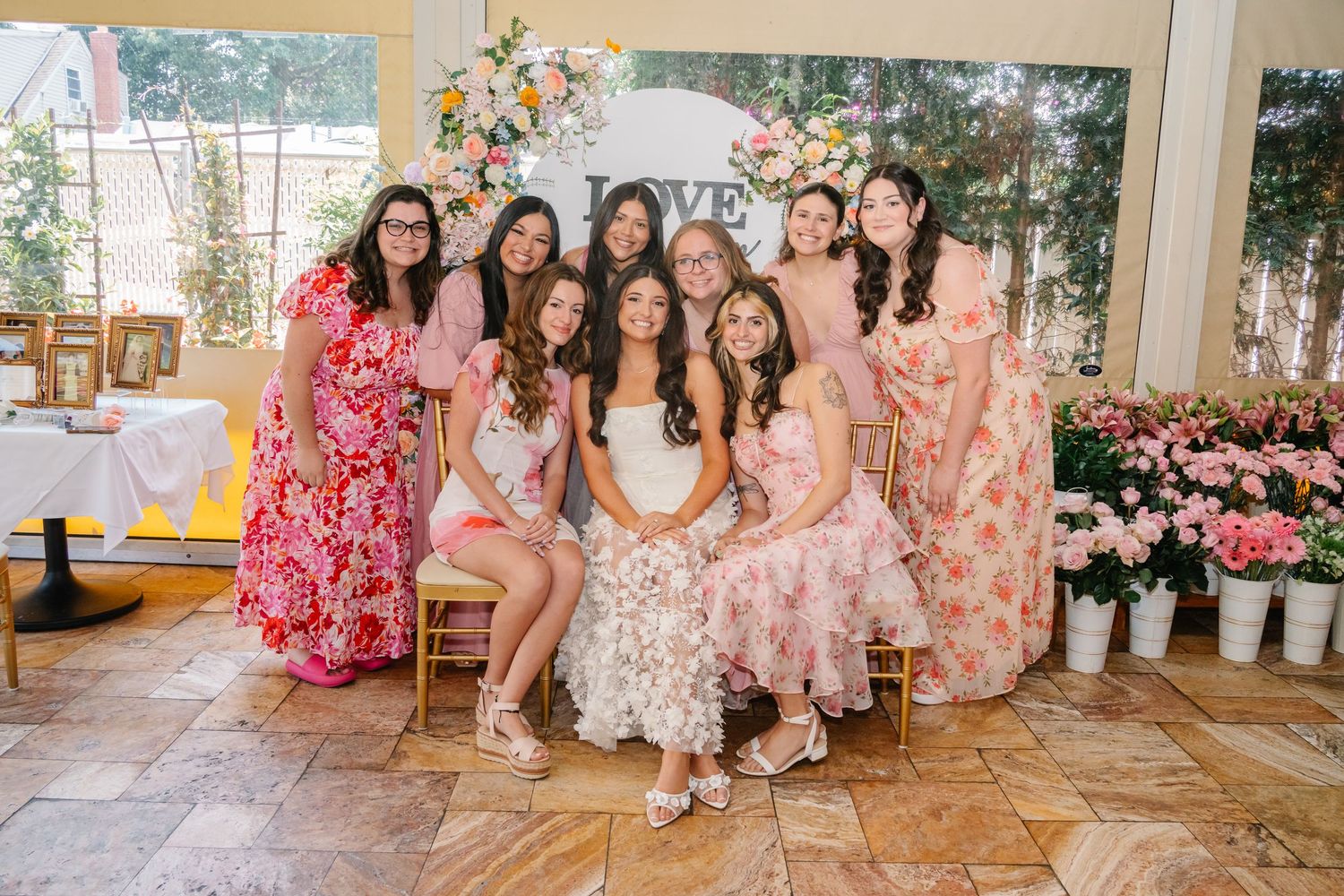 Group celebration with floral decorations and pink color scheme.