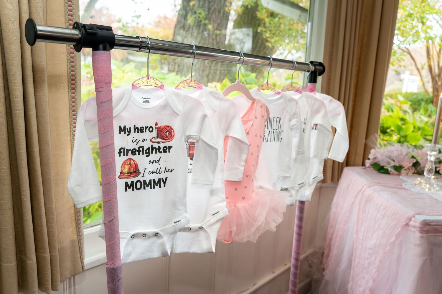 Pink and white decorations hang on display for a baby shower celebration.