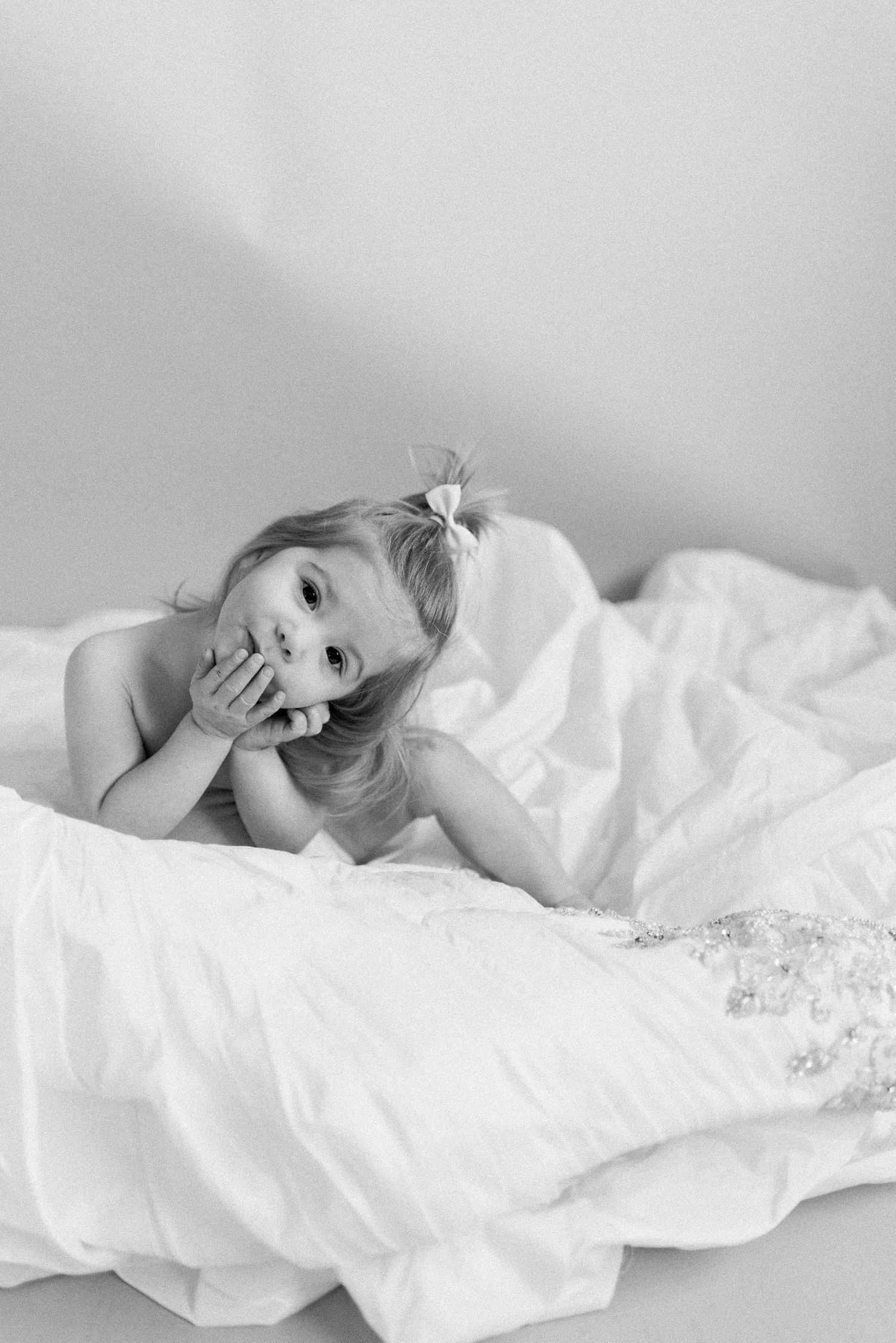Candid black and white portrait showing pure joy among soft white fabrics.