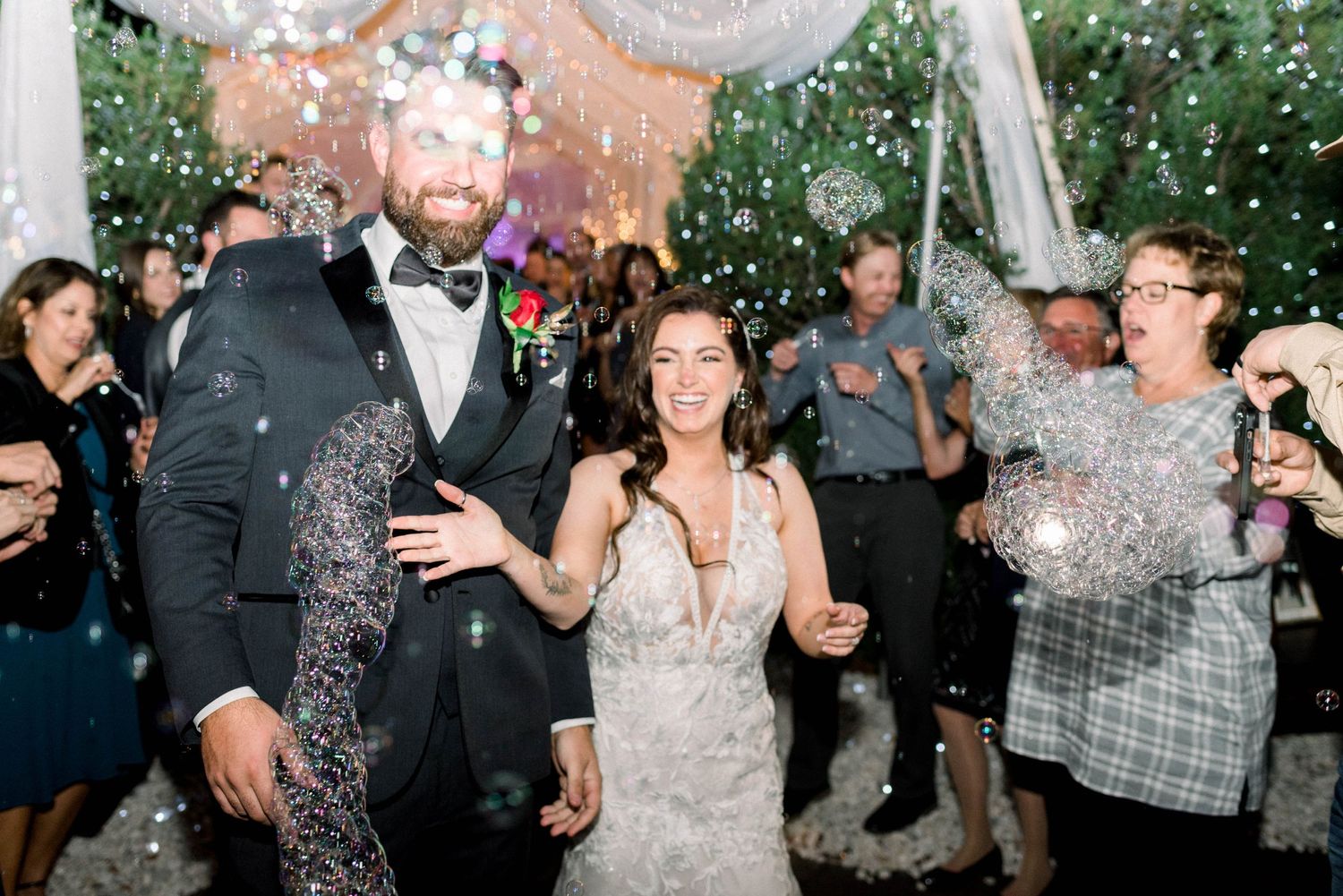 Happy couple celebrating with guests as confetti falls during wedding reception.