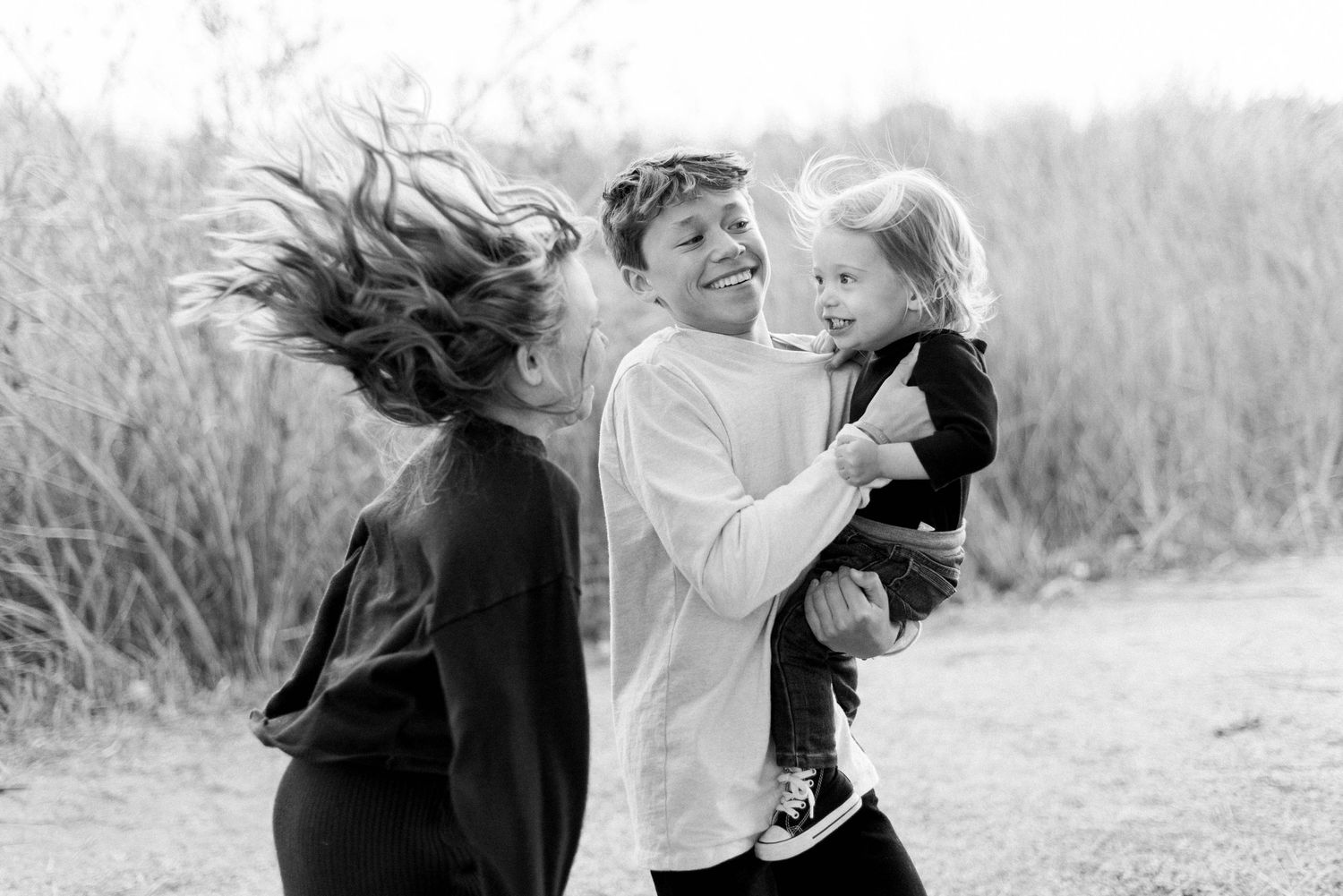 Young siblings jumping in the air with hair flying around