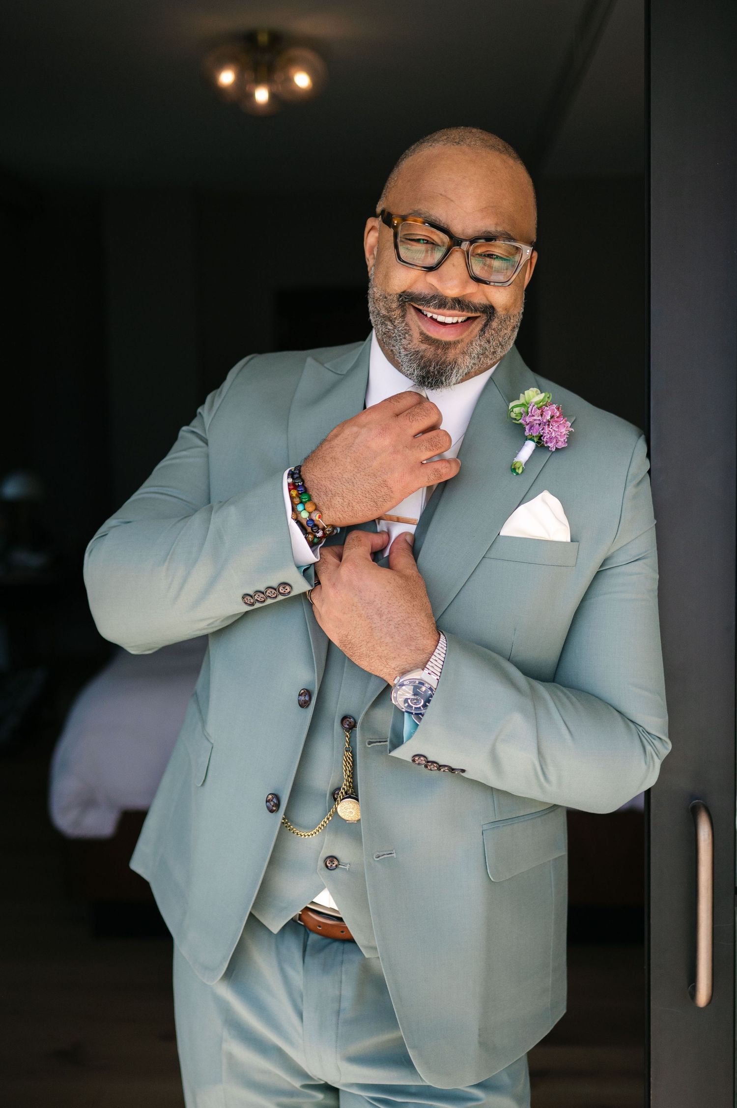 A person in a light blue suit and glasses poses with joyful expressions in a photo series.