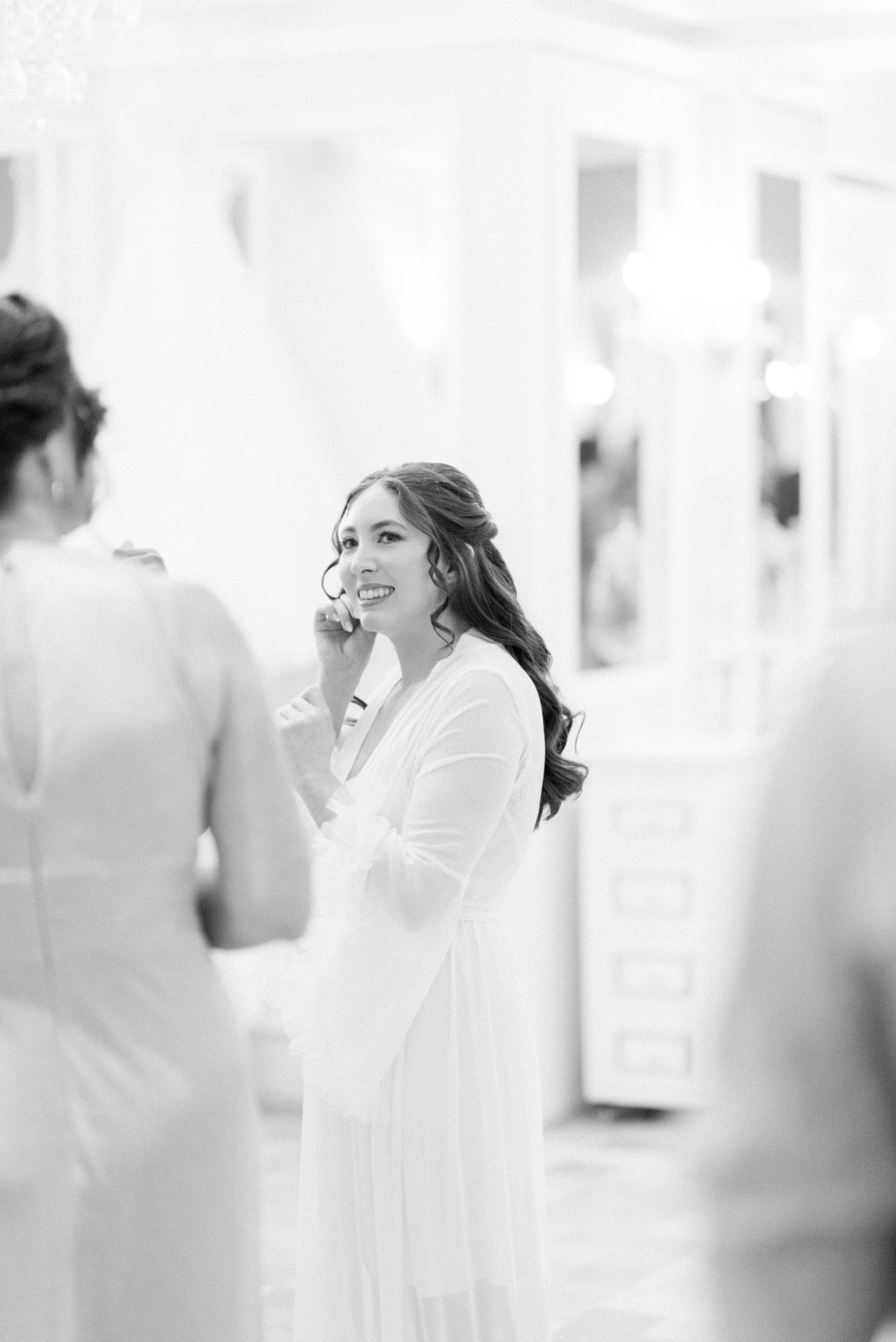 Elegant bridal preparation moment captured in black and white photography.