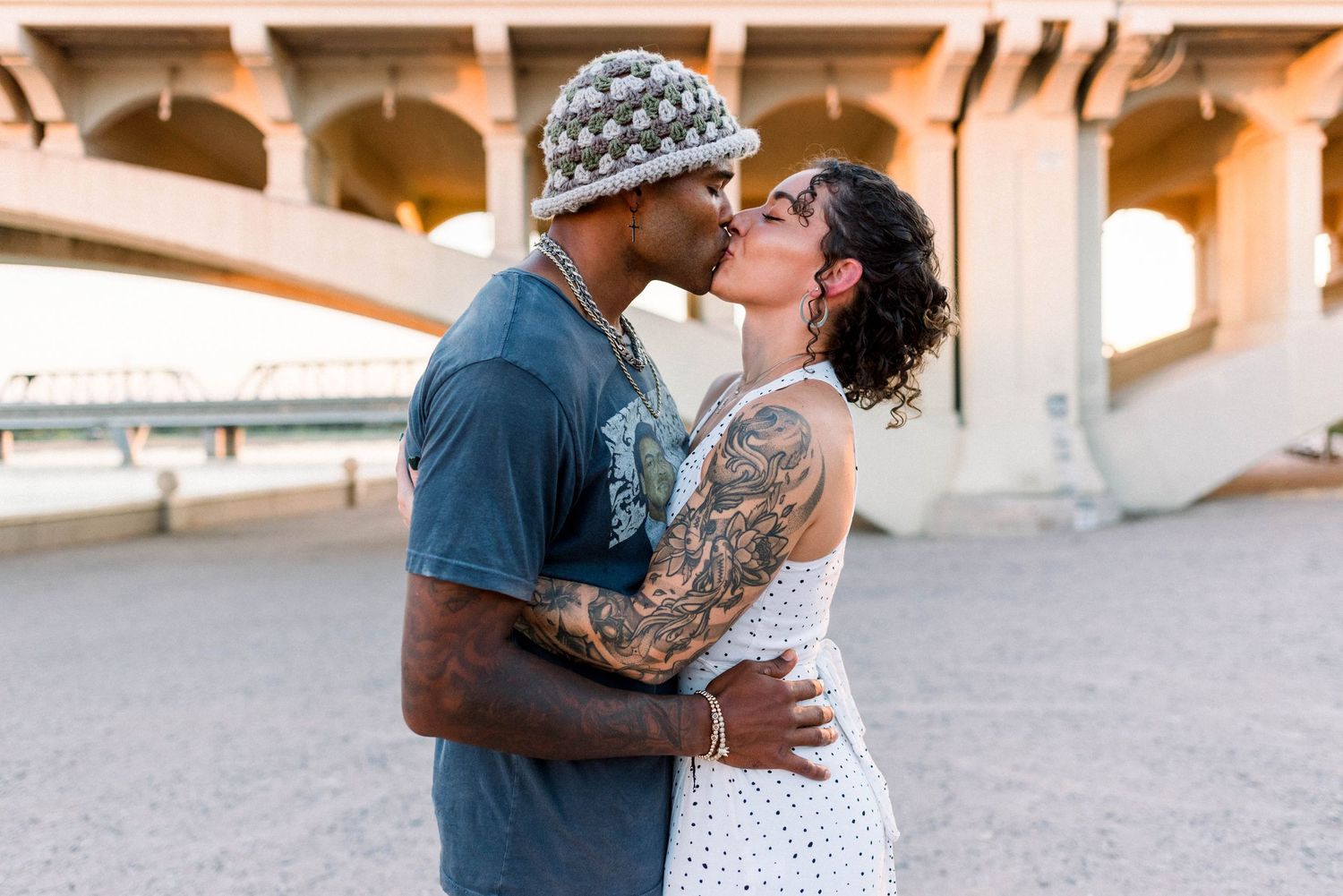 A romantic couple shares a tender kiss outdoors during their wedding photoshoot.