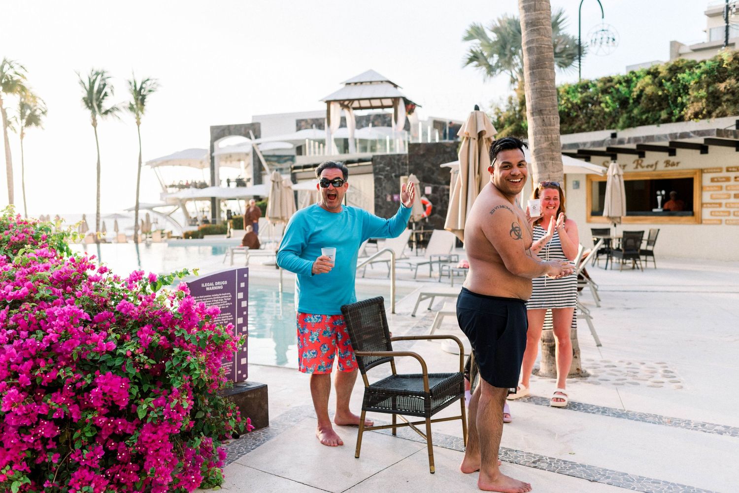 Casual beachside scene with bougainvillea flowers and palm trees at tropical resort.