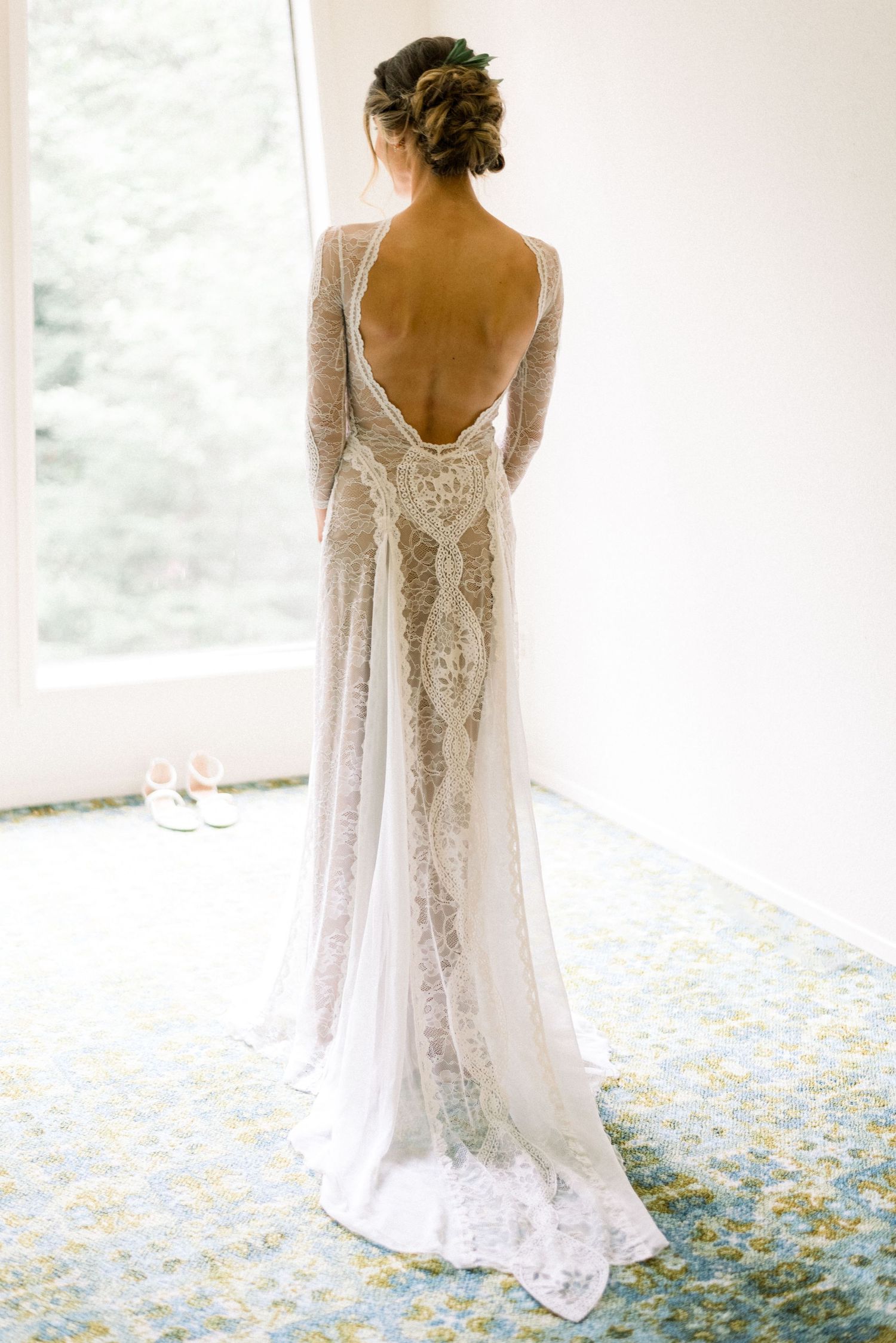 Back view of a bride wearing a lace wedding gown with an open back design.