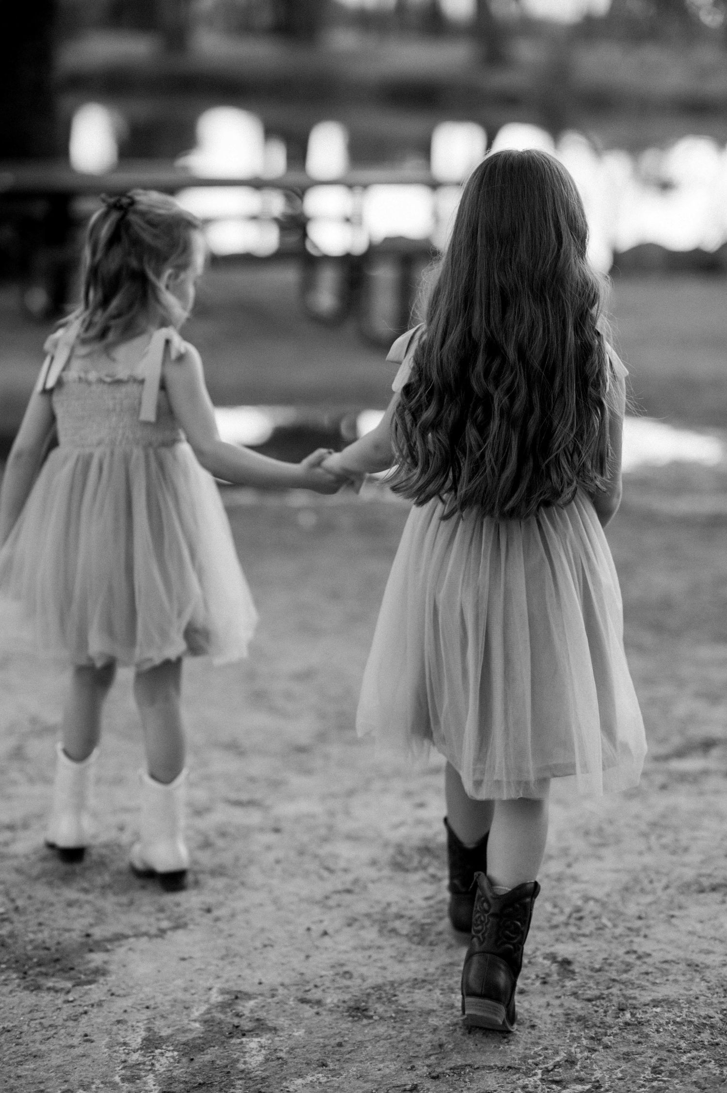 Black and white photo series of children in dresses walking away from camera.