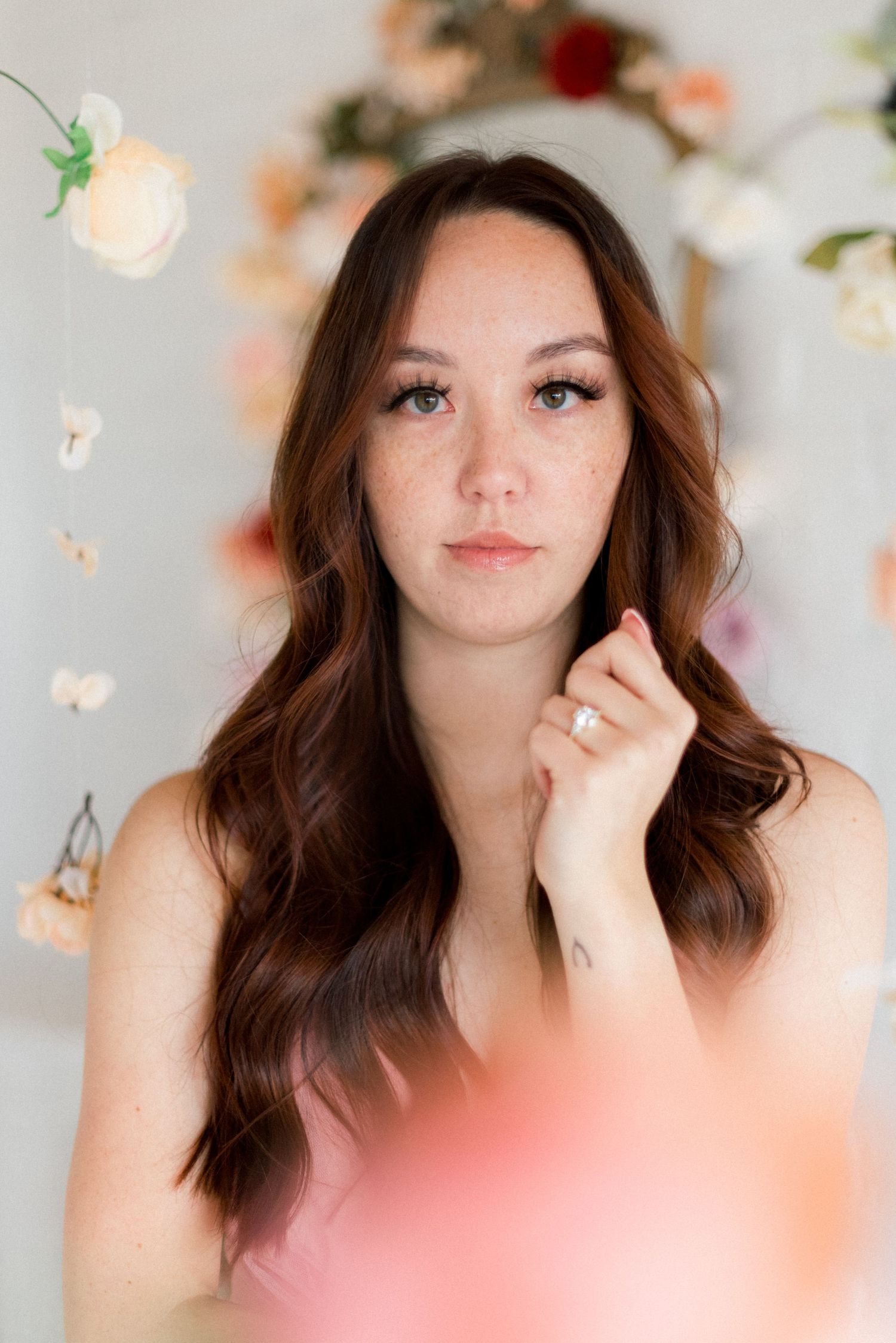 Soft romantic portrait with floating flowers and gentle lighting.