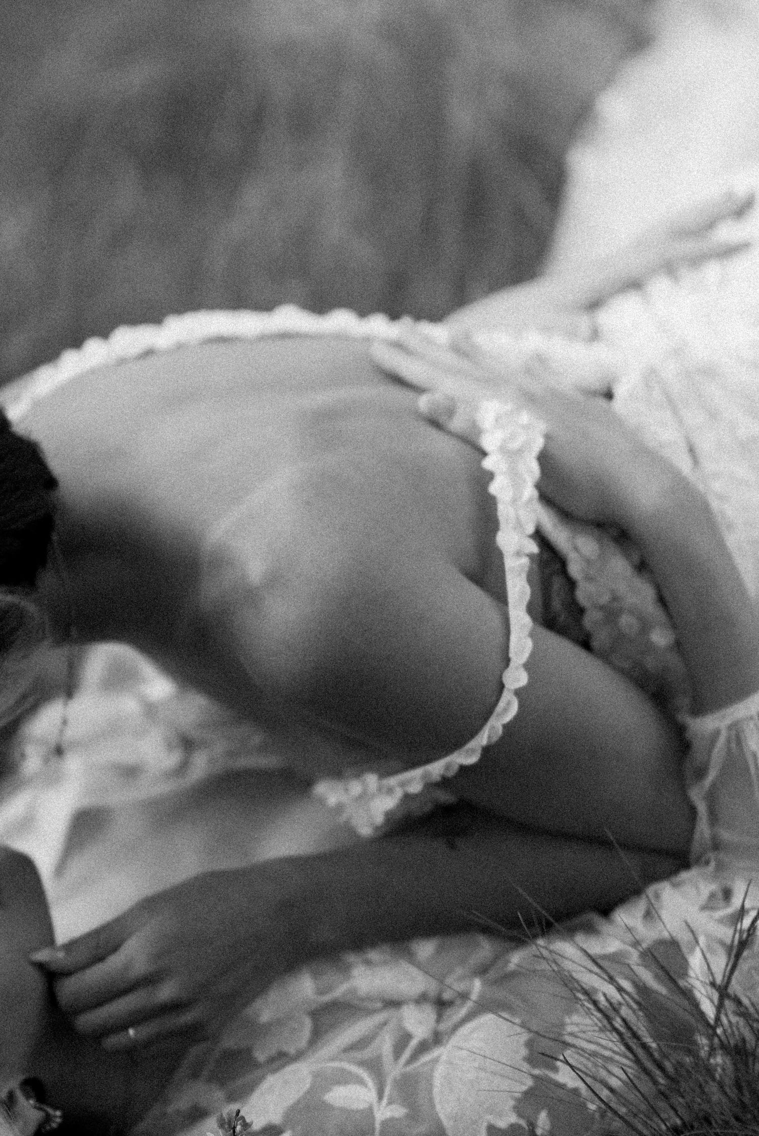 A delicate lace strap against skin in an intimate black and white boudoir photograph.