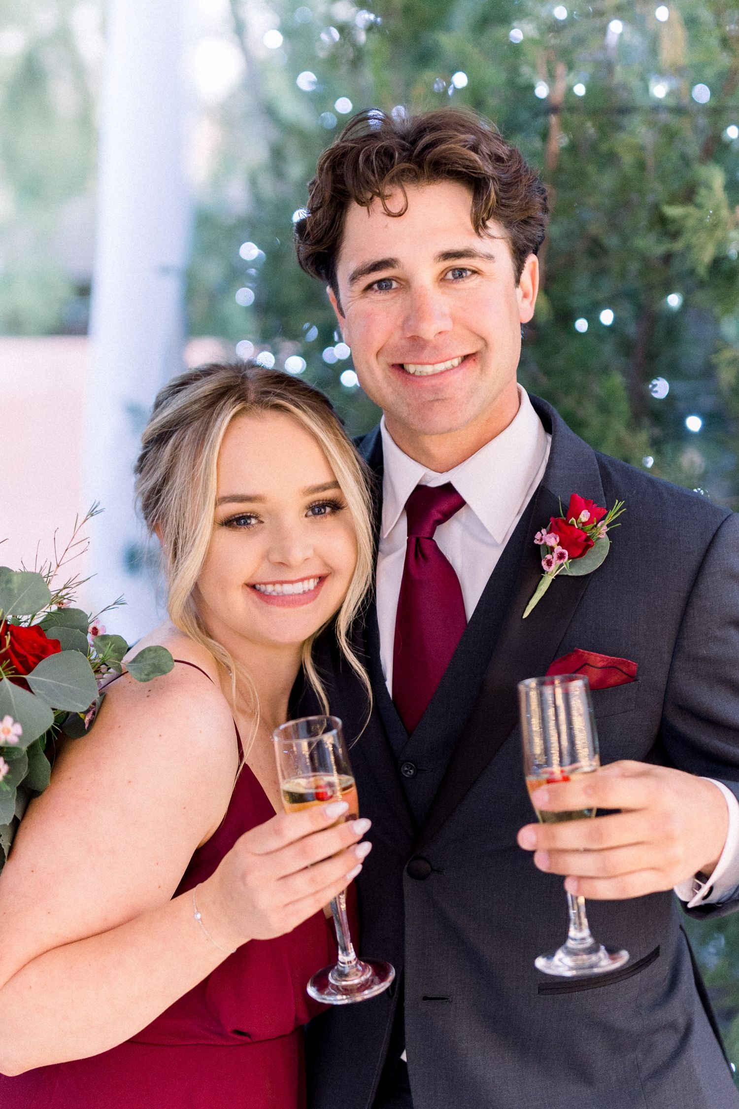 Wedding attendees in formal attire toasting with champagne glasses.