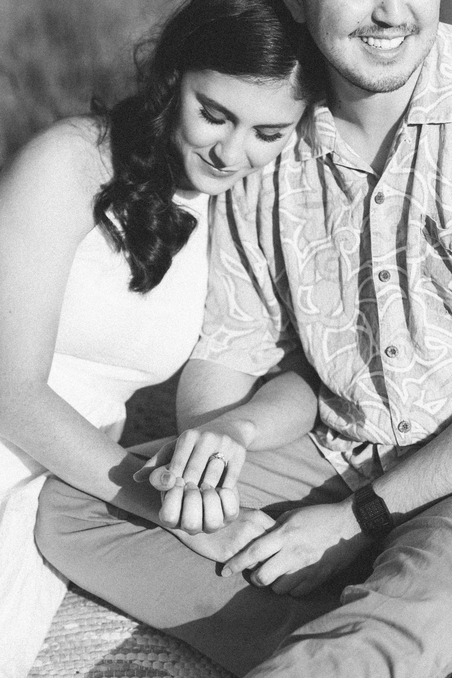 Intimate black and white photo of couple holding hands during engagement session.