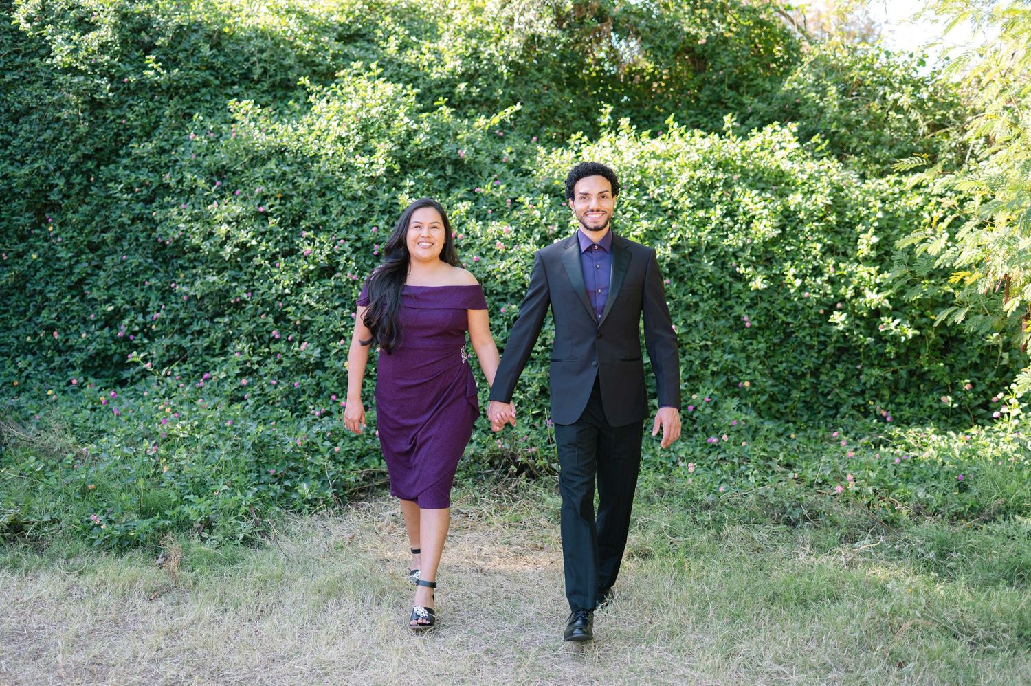 A couple walks together outdoors on a grassy path in a romantic sequence of candid photos.