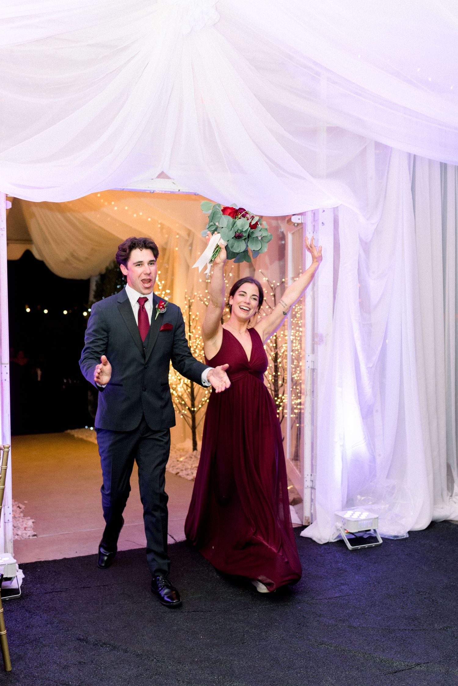 Wedding party members making grand entrance into reception venue.