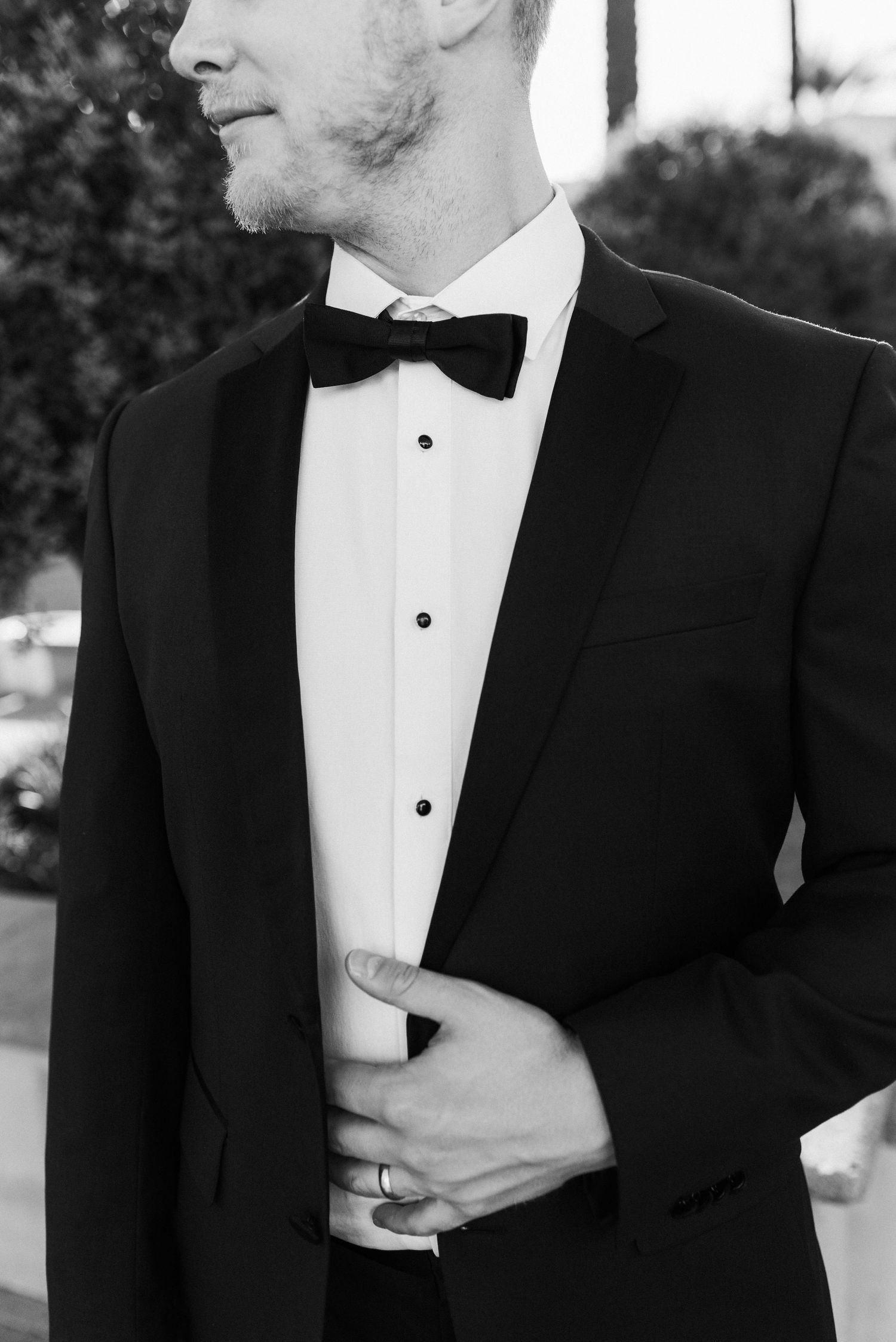 Close up detail of a black bowtie and tuxedo with white shirt studs.