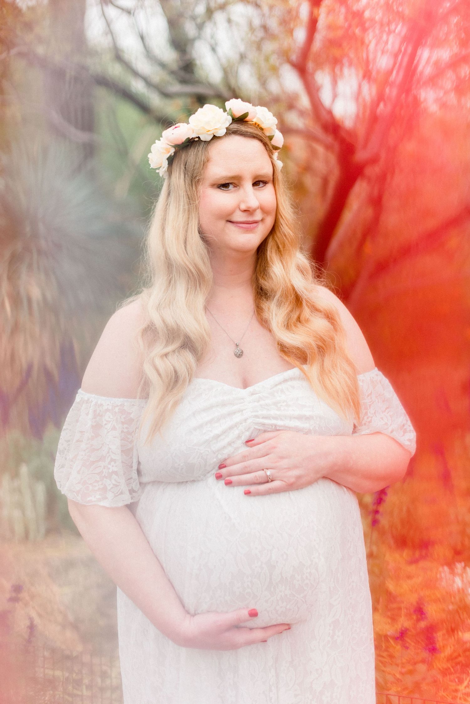 Colorful maternity portrait with vibrant red tones and soft focus effects.