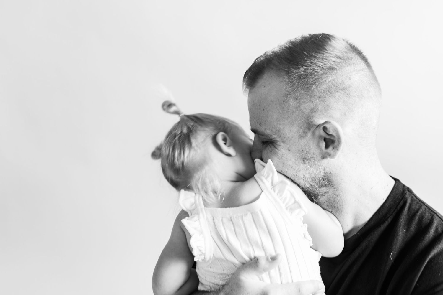 Black and white portrait capturing an intimate moment between parent and child.