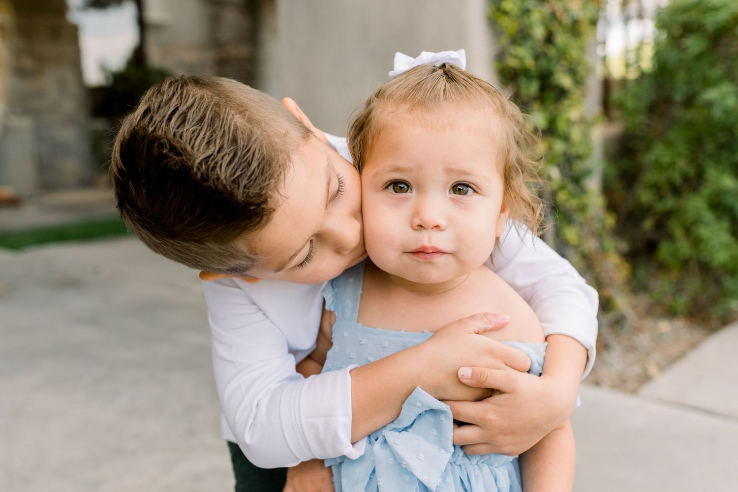 sweet portrait of brother giving a kiss to little sister