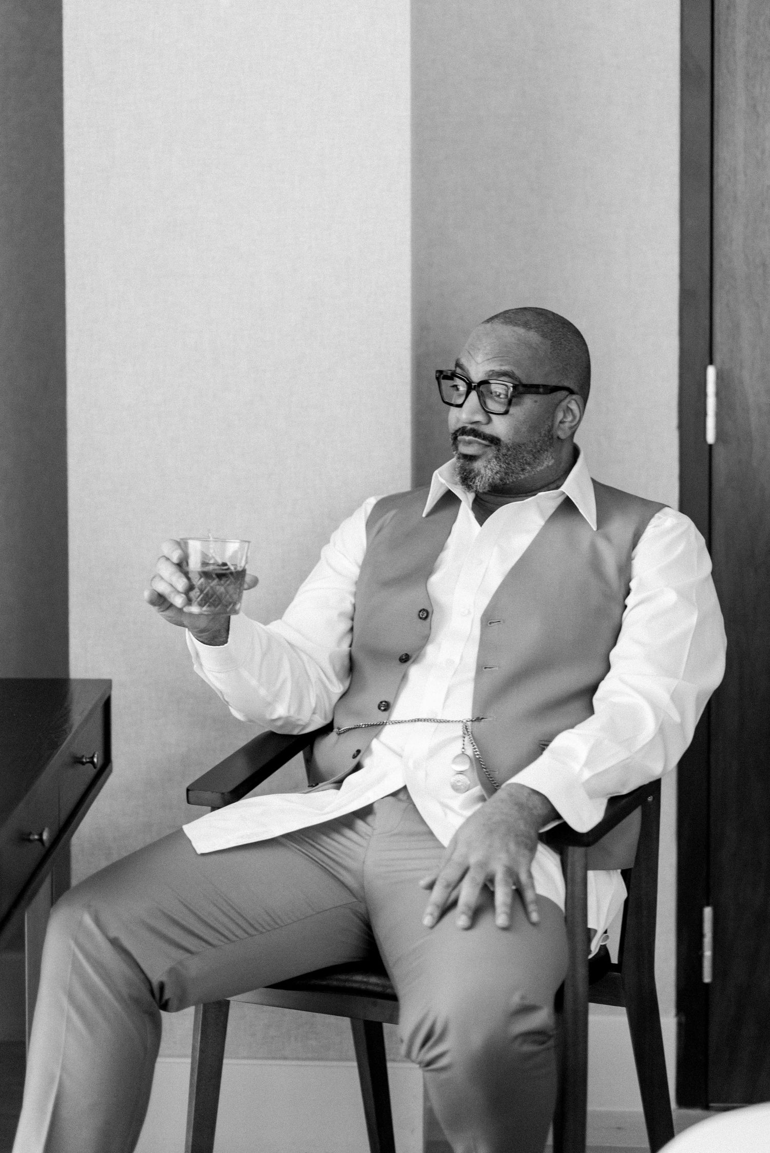A sequence of black and white photos showing a person in a vest and glasses relaxing in a chair.