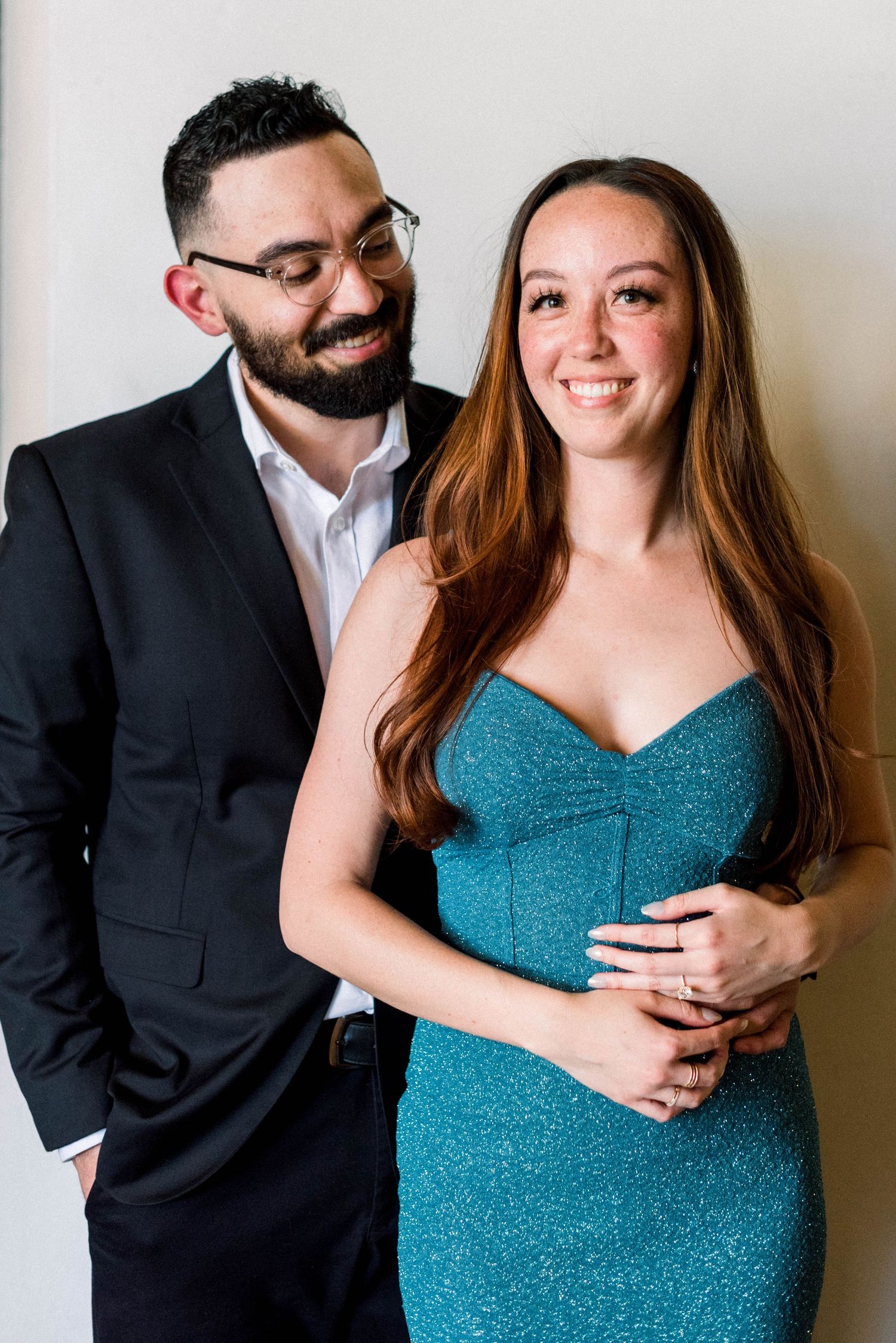 Couple poses together in formal attire with a playful expression.